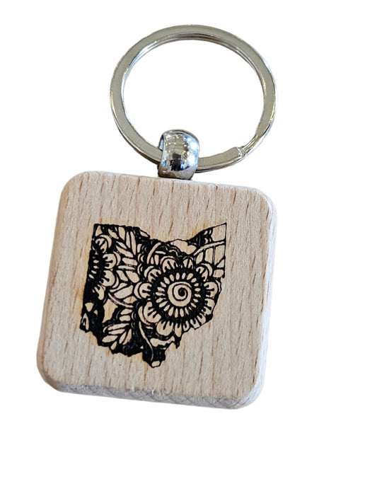 Wooden keychain with owl design on a wooden surface