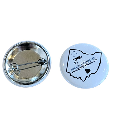 Button badge with a map design on a wooden surface