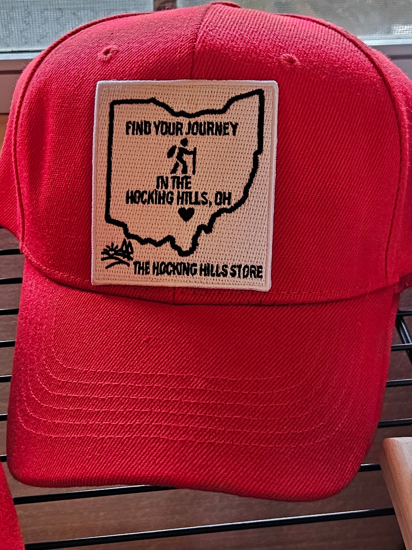 Red cap with a patch on a wooden surface