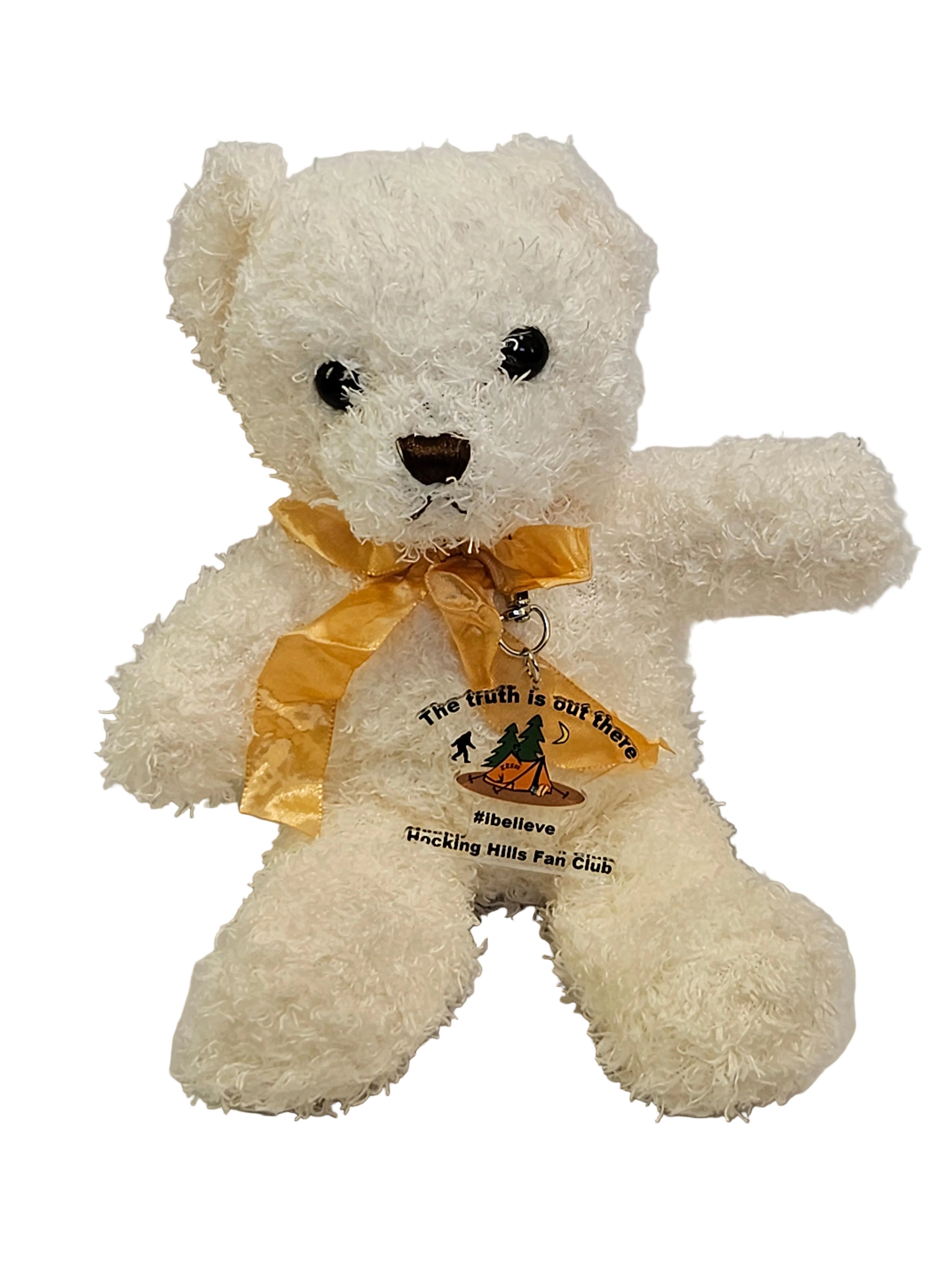 White teddy bear with a yellow ribbon on a light gray background