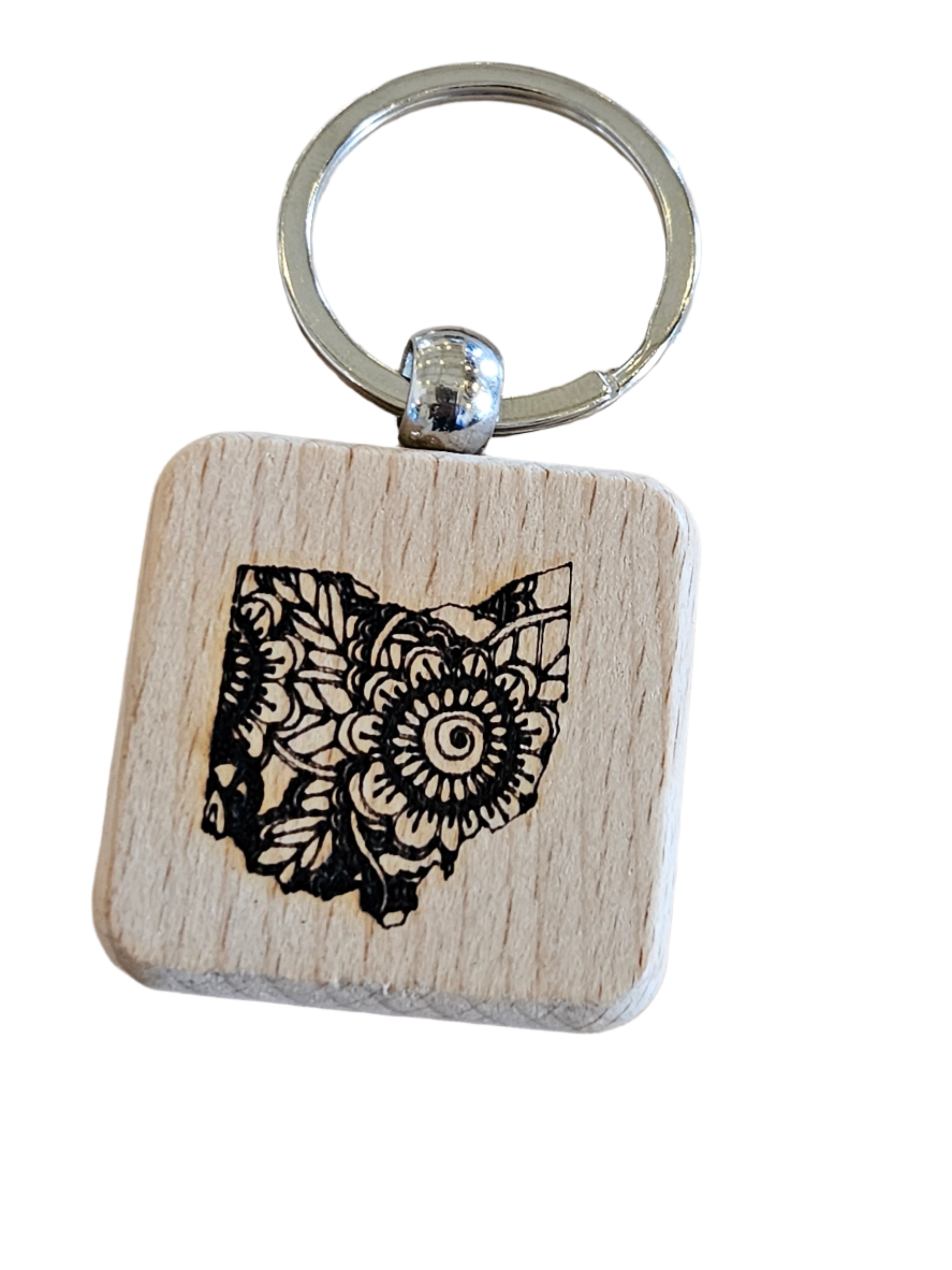 Wooden keychain with owl design on a wooden surface