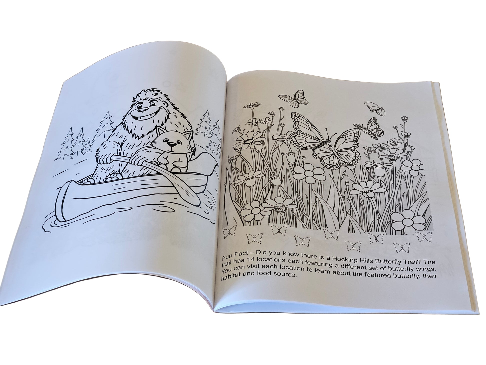 Open coloring book with animal and nature-themed illustrations on a wooden surface