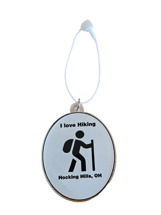 Keychain with hiking icon and text on a wooden surface