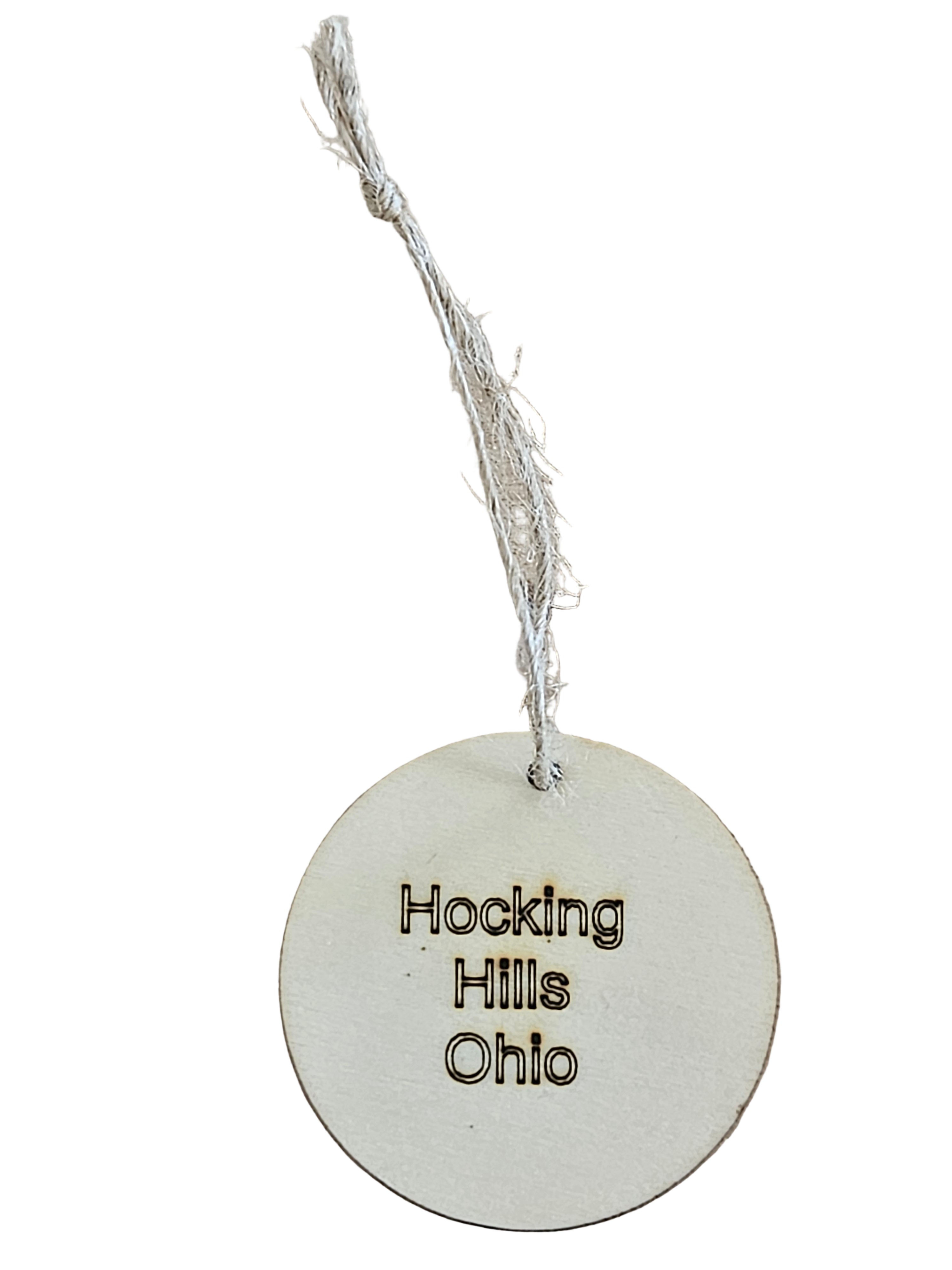 Round white tag with 'Hocking Hills Ohio' text on a white surface