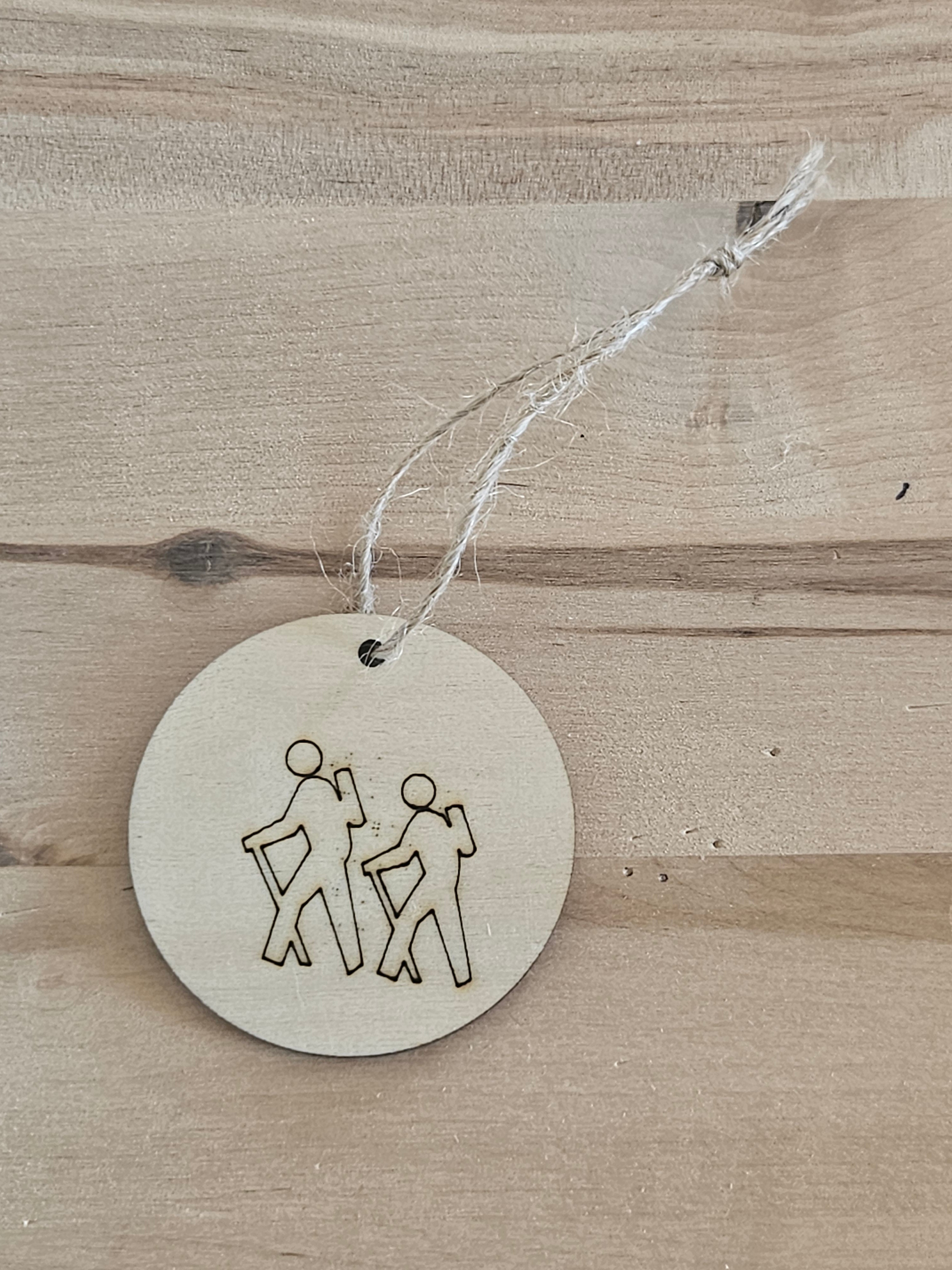 Round metal tag with engraved design on a white surface