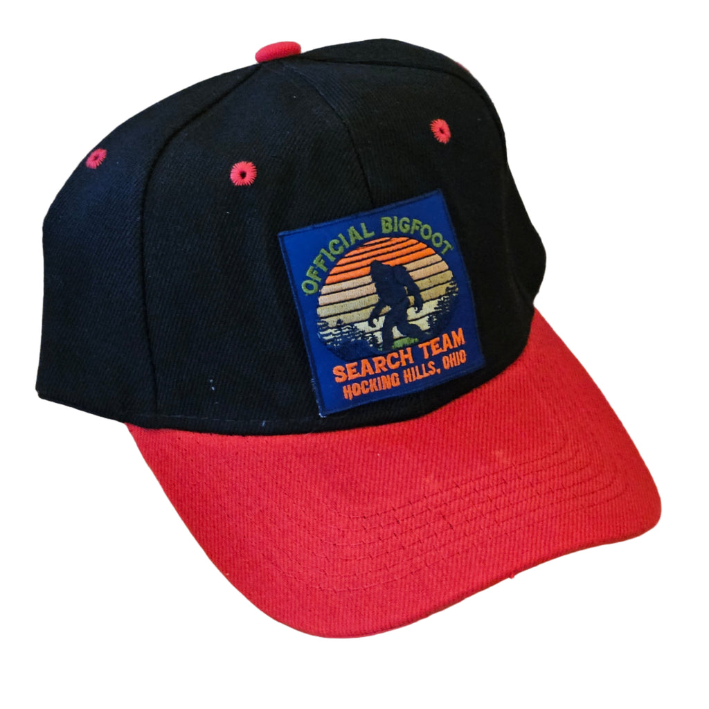 Black cap with a colorful patch on a red cap against a white background