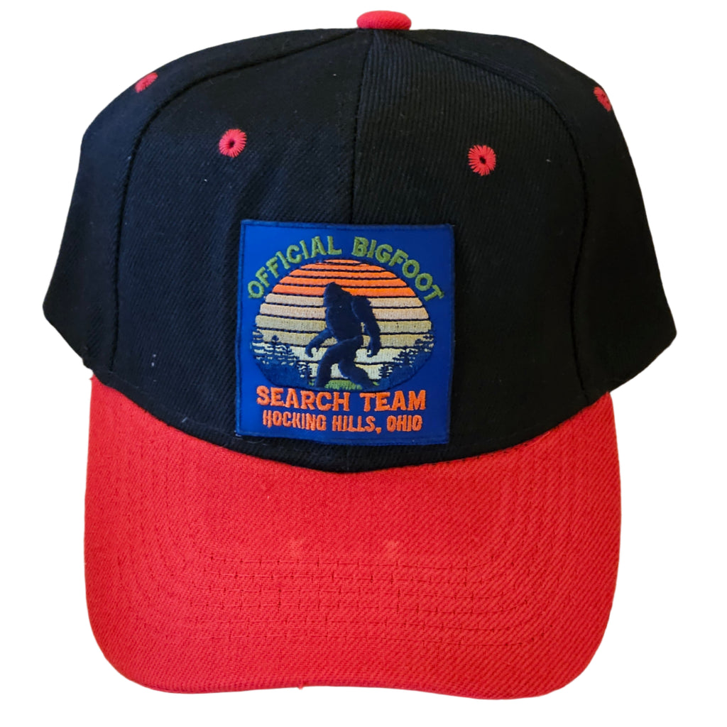 Black and red cap with a blue patch on a white surface