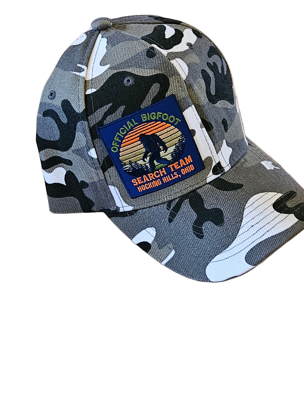 Camouflage-patterned cap with a patch on a wooden surface