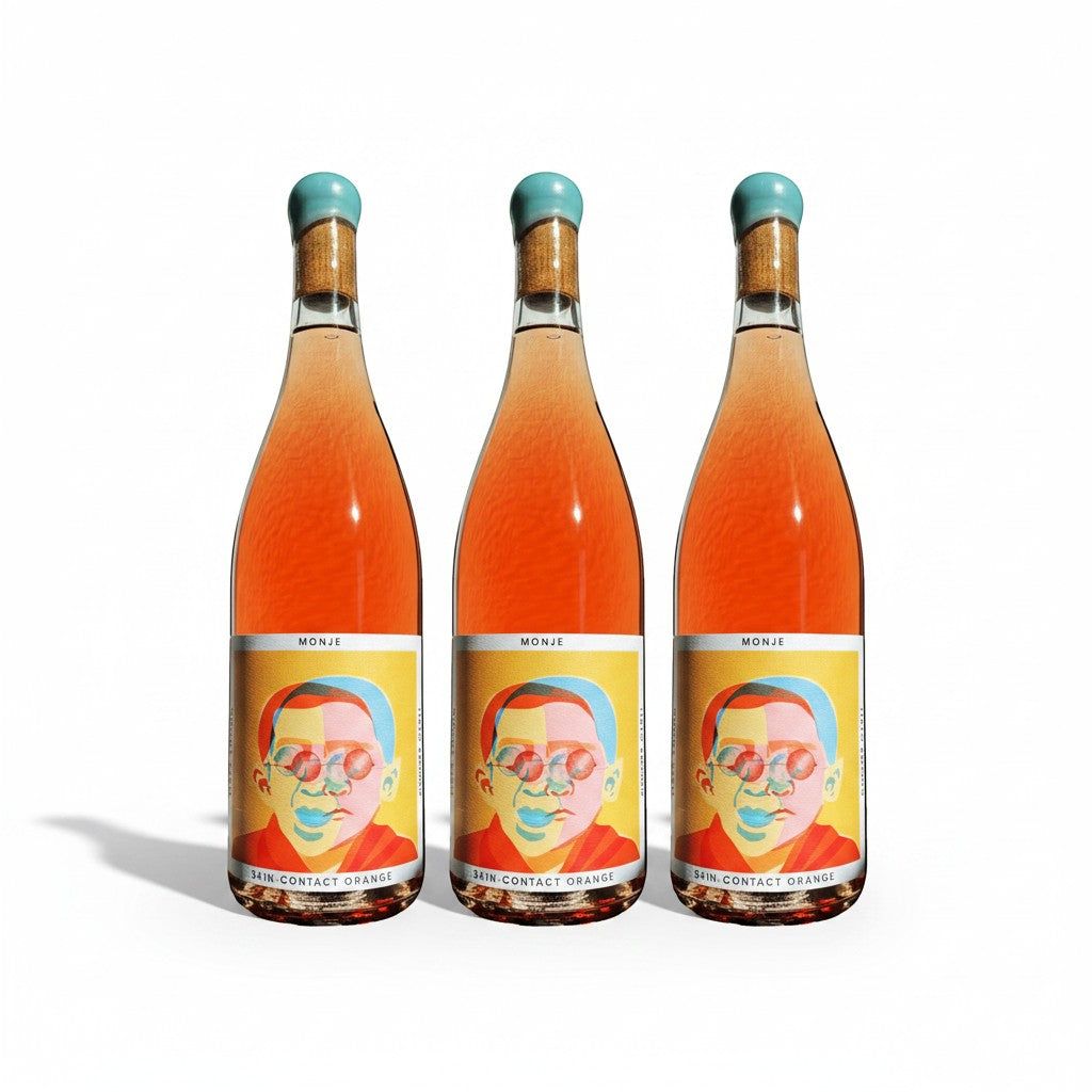 The Hocking Hills Store Monje 7-day skin-contact orange wine in clear bottles with colourful, abstract portrait labels. Serve chilled.