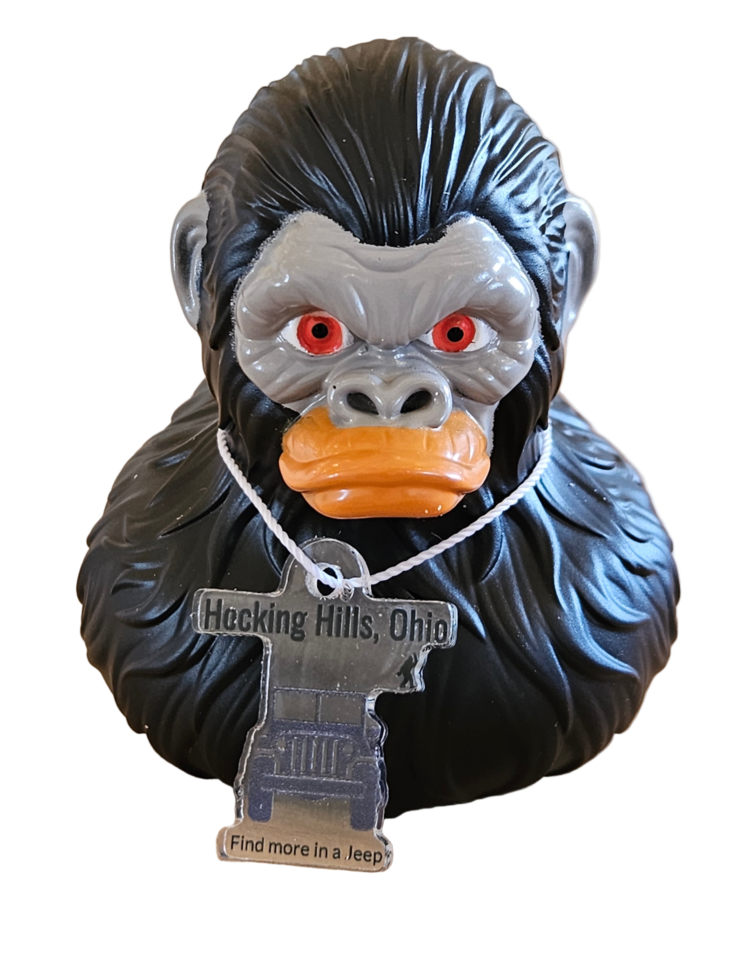 Decorative door stop shaped like a beaver with a tag on a wooden surface