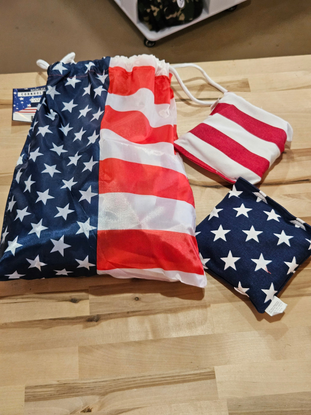 The Hocking Hills Store corn-hole bag set featuring American flag patterns on a drawstring storage bag and two bean bags