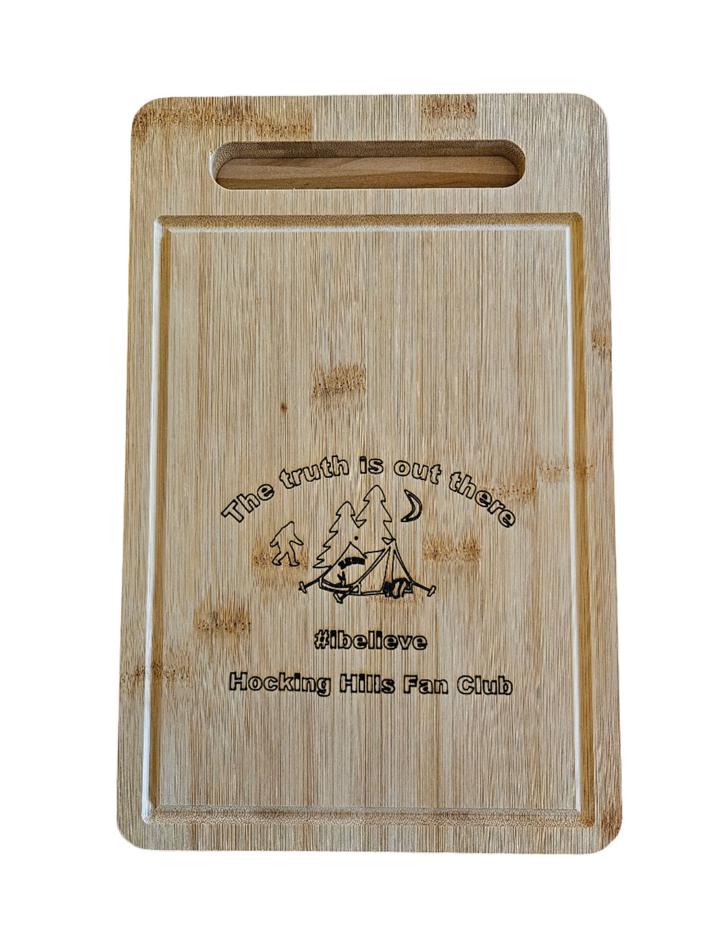 The Hocking Hills Store rectangle bamboo cutting board with a campsite graphic and "The truth is out there #ibelieve Hocking Hills Fan Club" text.