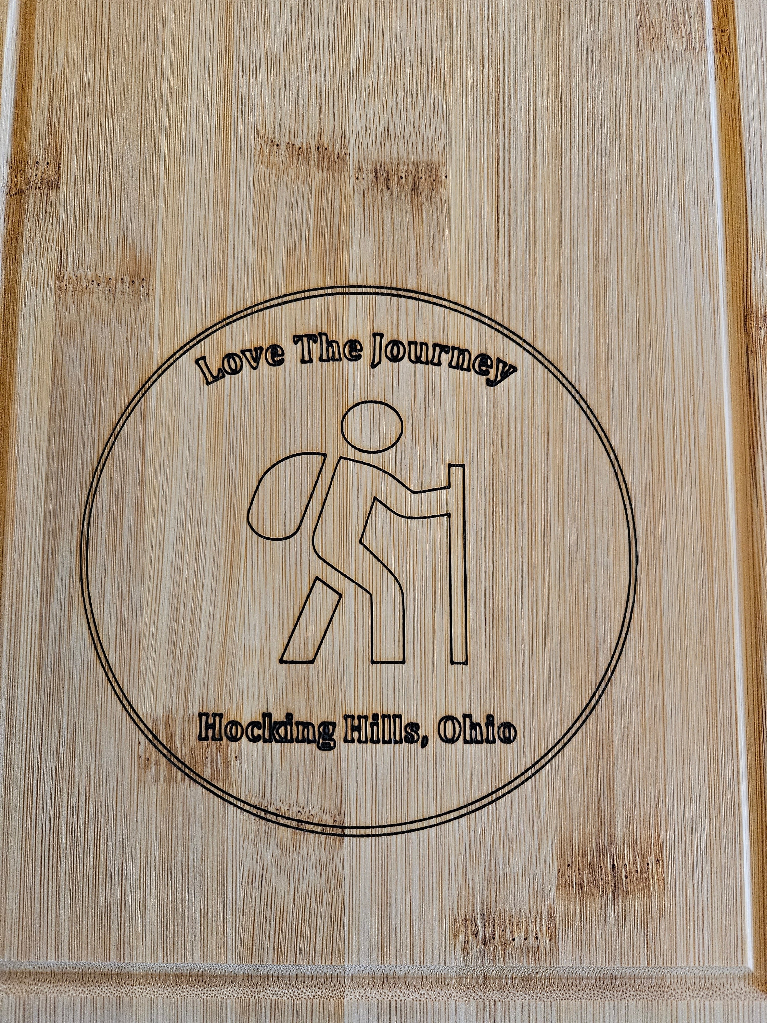 The Hocking Hills Store Rectangle bamboo cutting board with engraved hiker graphic and "Love The Journey Hocking Hills, Ohio" text.