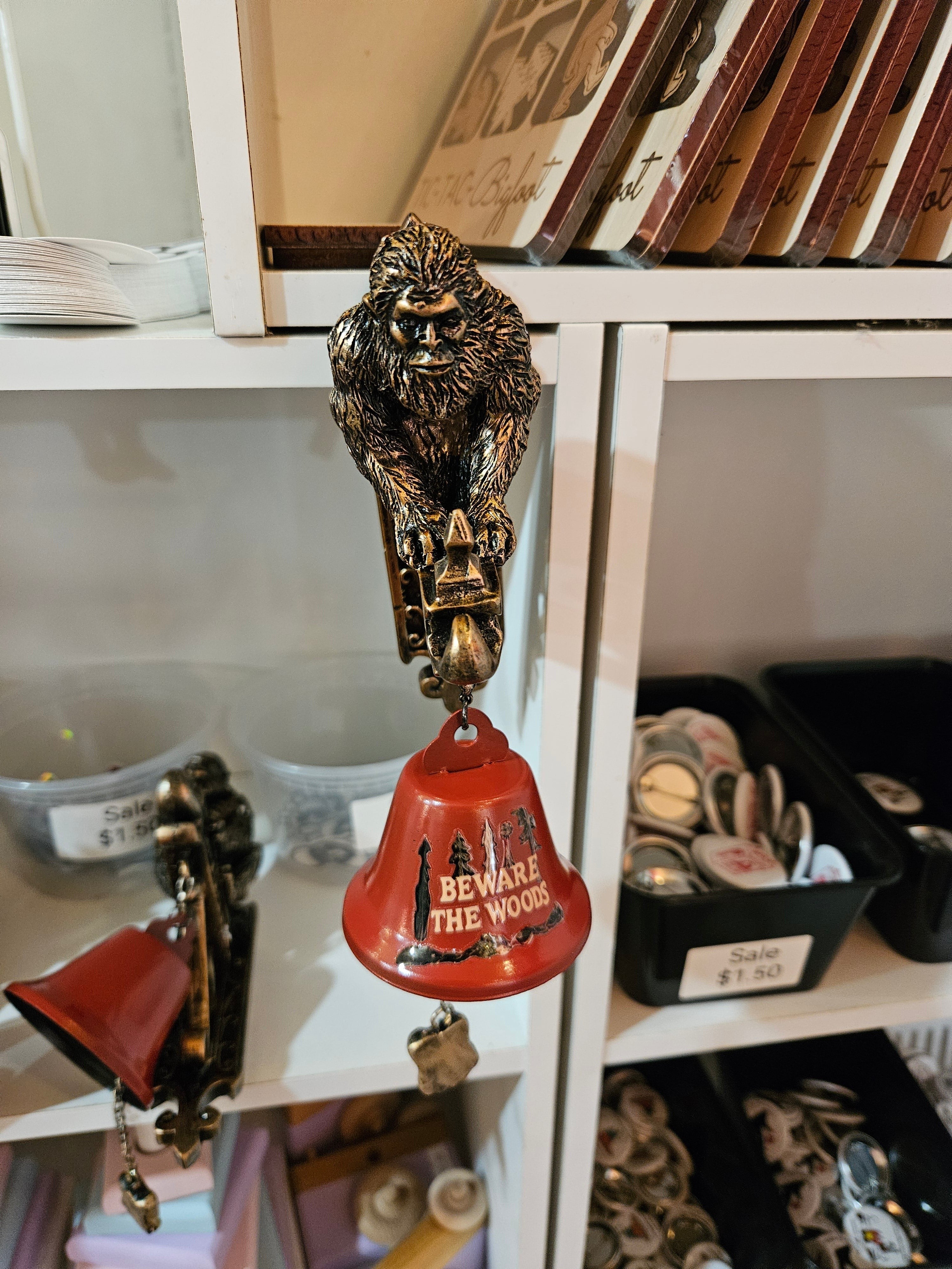 The Hocking Hills Store Bigfoot Wall Art and Bell features a metal Bigfoot figure and a red bell with "BEWARE THE WOODS" text.