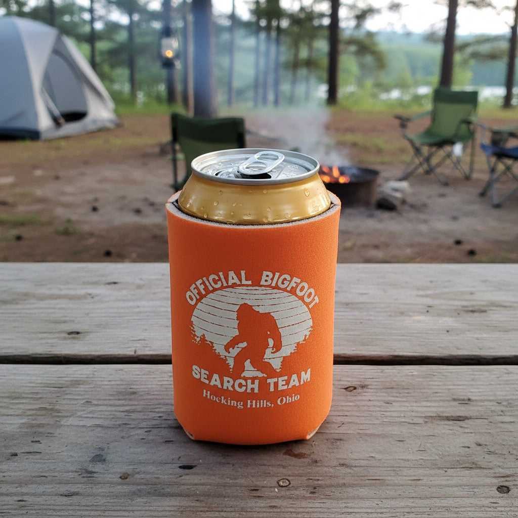The Hocking Hills Store Official Bigfoot Search Team orange can cooler with a white Bigfoot graphic and text.