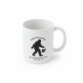 The Hocking Hills Store white ceramic coffee mug with a black Bigfoot silhouette and "Enjoy The Journey" text.