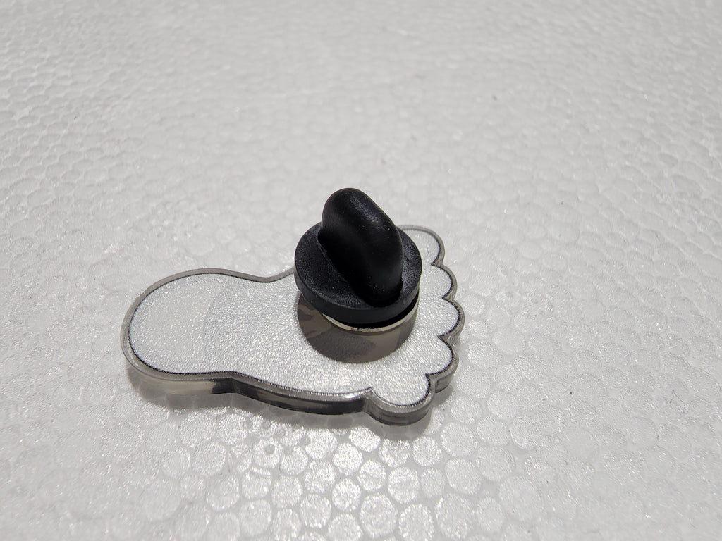 The Hocking Hills Store Bigfoot Hocking Hills enamel pin shaped like a footprint with a black backing pin.