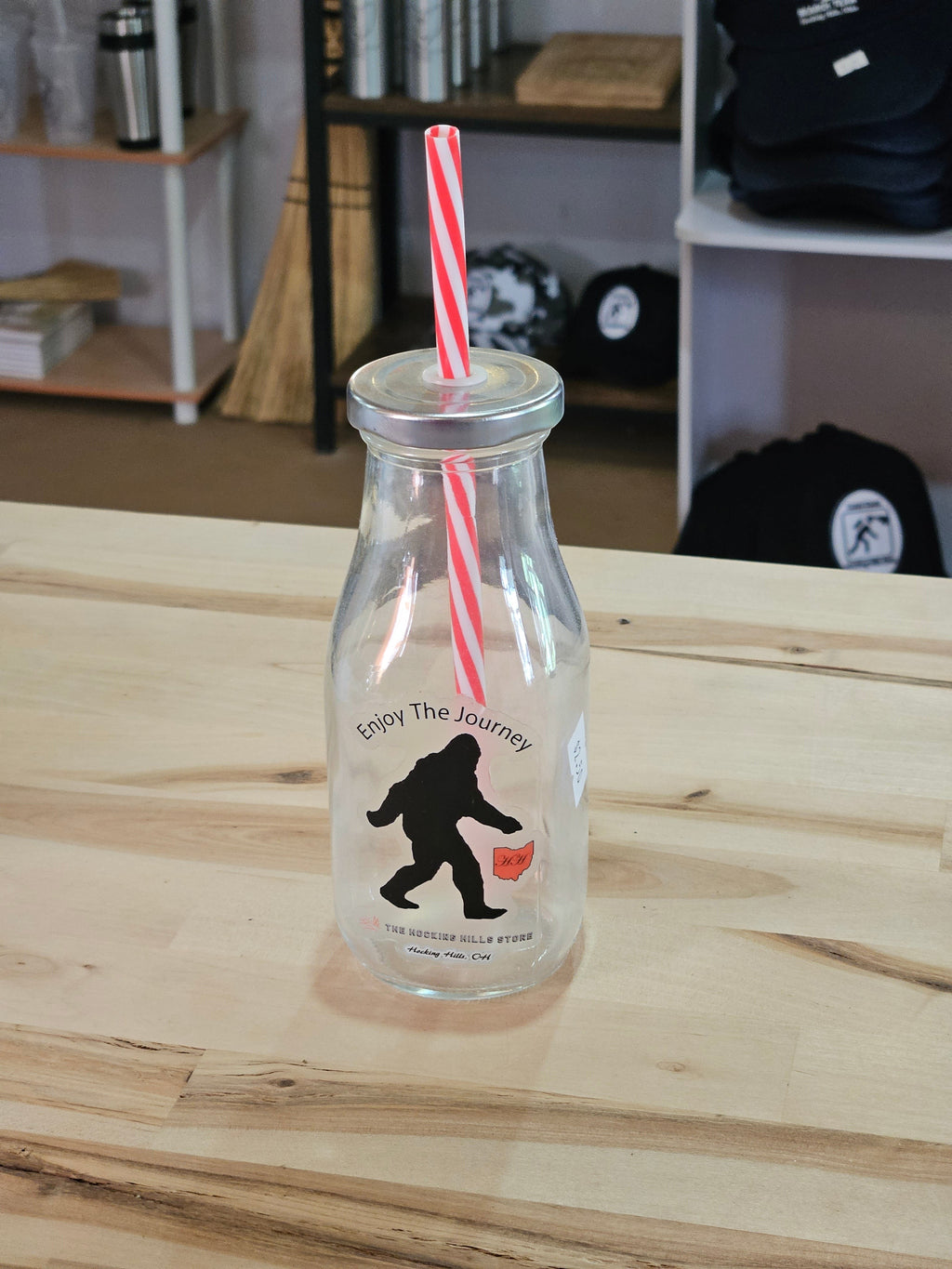 The Hocking Hills Store Bigfoot Glass Sipper with red and white striped straw. Features Bigfoot silhouette and Ohio map graphic.