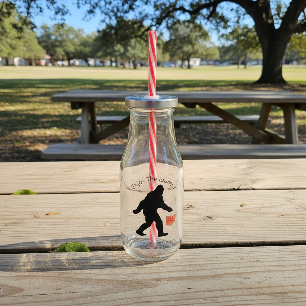 The Hocking Hills Store Bigfoot Glass Sipper with red and white striped straw. Features Bigfoot graphic and "Enjoy The Journey" text.