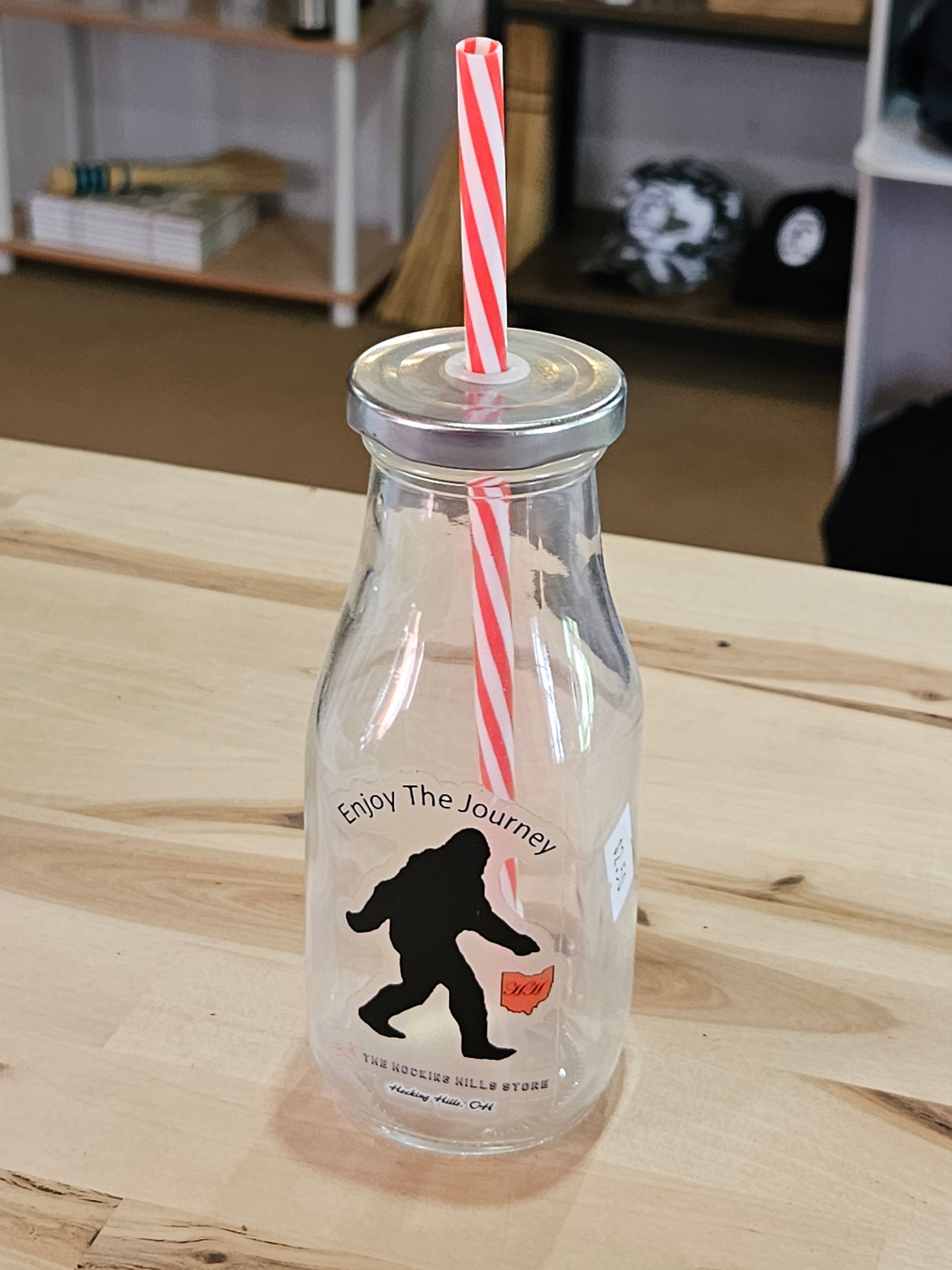 The Hocking Hills Store Bigfoot Glass Sipper with red and white striped straw. Features Bigfoot graphic and "Enjoy The Journey" text.