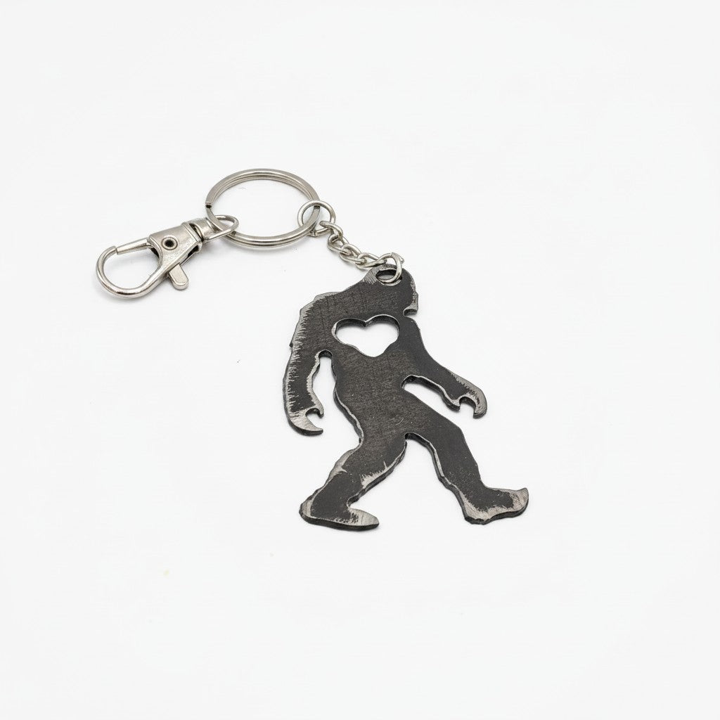 The Hocking Hills Store Bigfoot metal keychain with heart cutout. Dark grey metal.