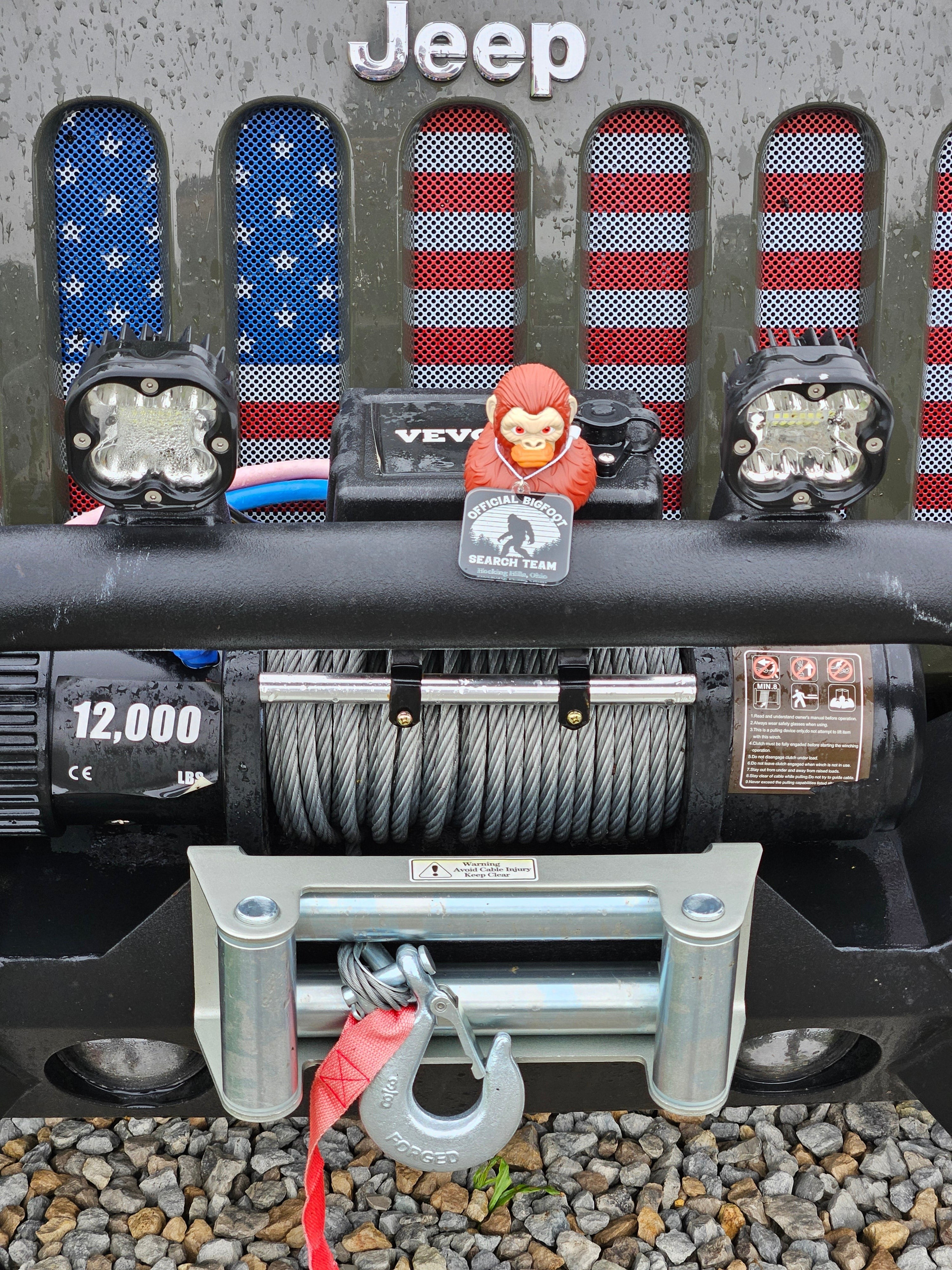 The Hocking Hills Store Bigfoot Jeep Ducks, a red Bigfoot figure with an 'Official Bigfoot Search Team' tag, attached to a Jeep grille with American flag inserts.