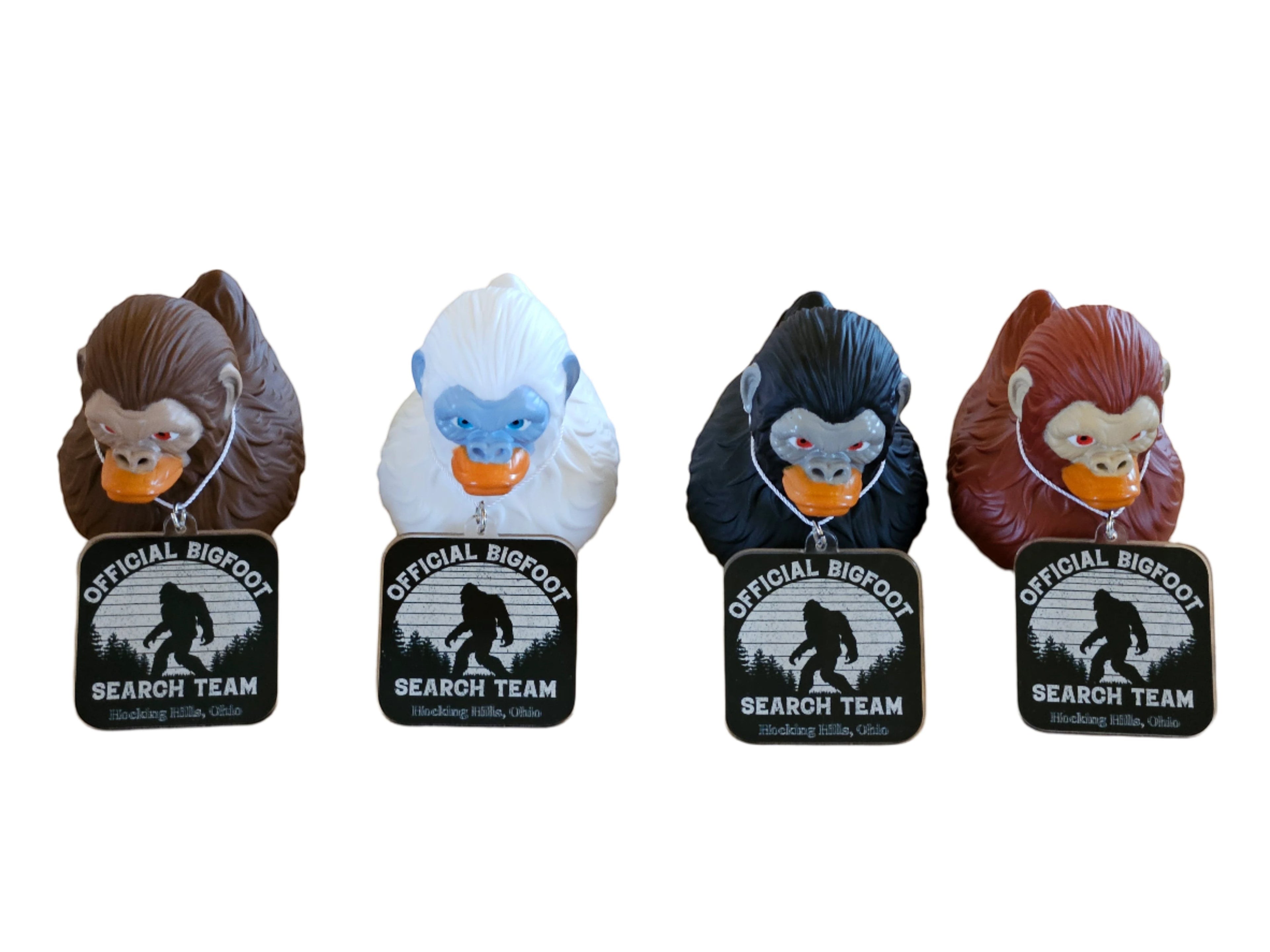 The Hocking Hills Store Bigfoot Jeep Ducks come in brown, white, black, and red. Each duck has an orange beak and a tag that says "Official Bigfoot Search Team".