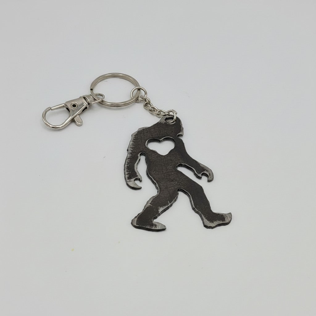 The Hocking Hills Store Bigfoot metal keychain with heart cutout detail and silver clasp.