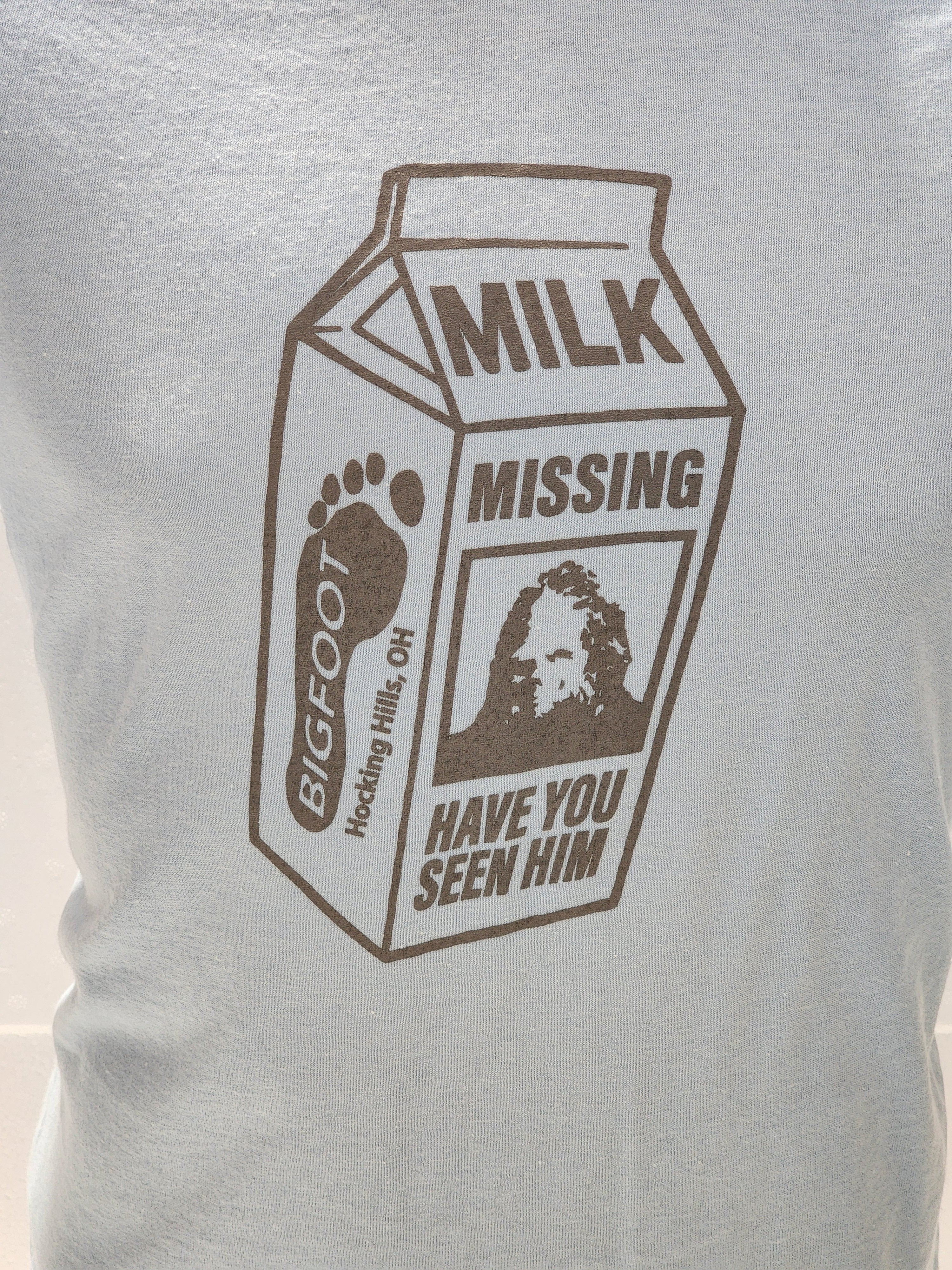 The Hocking Hills Store Bigfoot milk carton missing t-shirt in light blue with brown graphic. Features Bigfoot footprint and image.