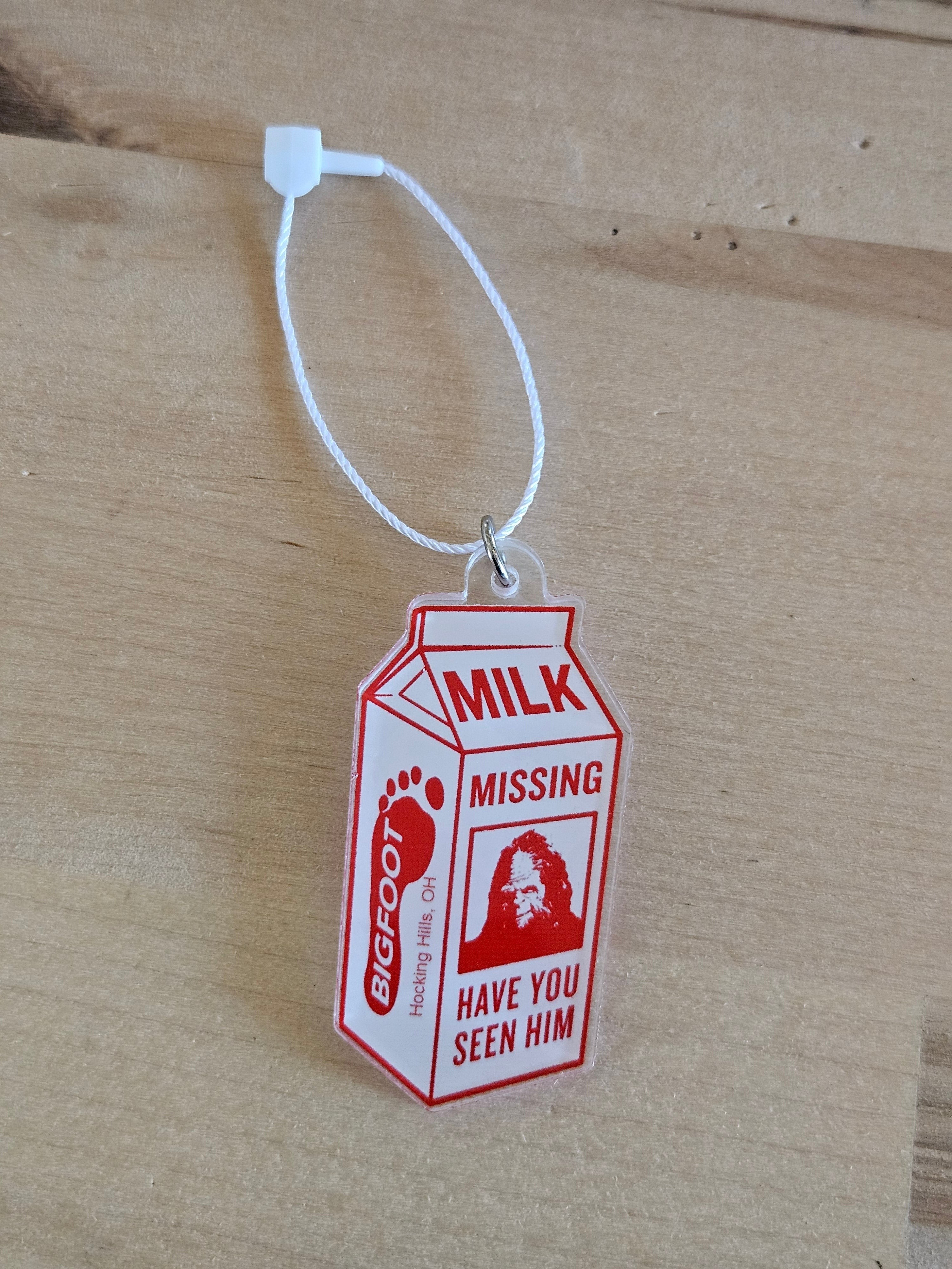 The Hocking Hills Store Bigfoot milk carton ornament with red text and Bigfoot image. Acrylic, clear with red design.