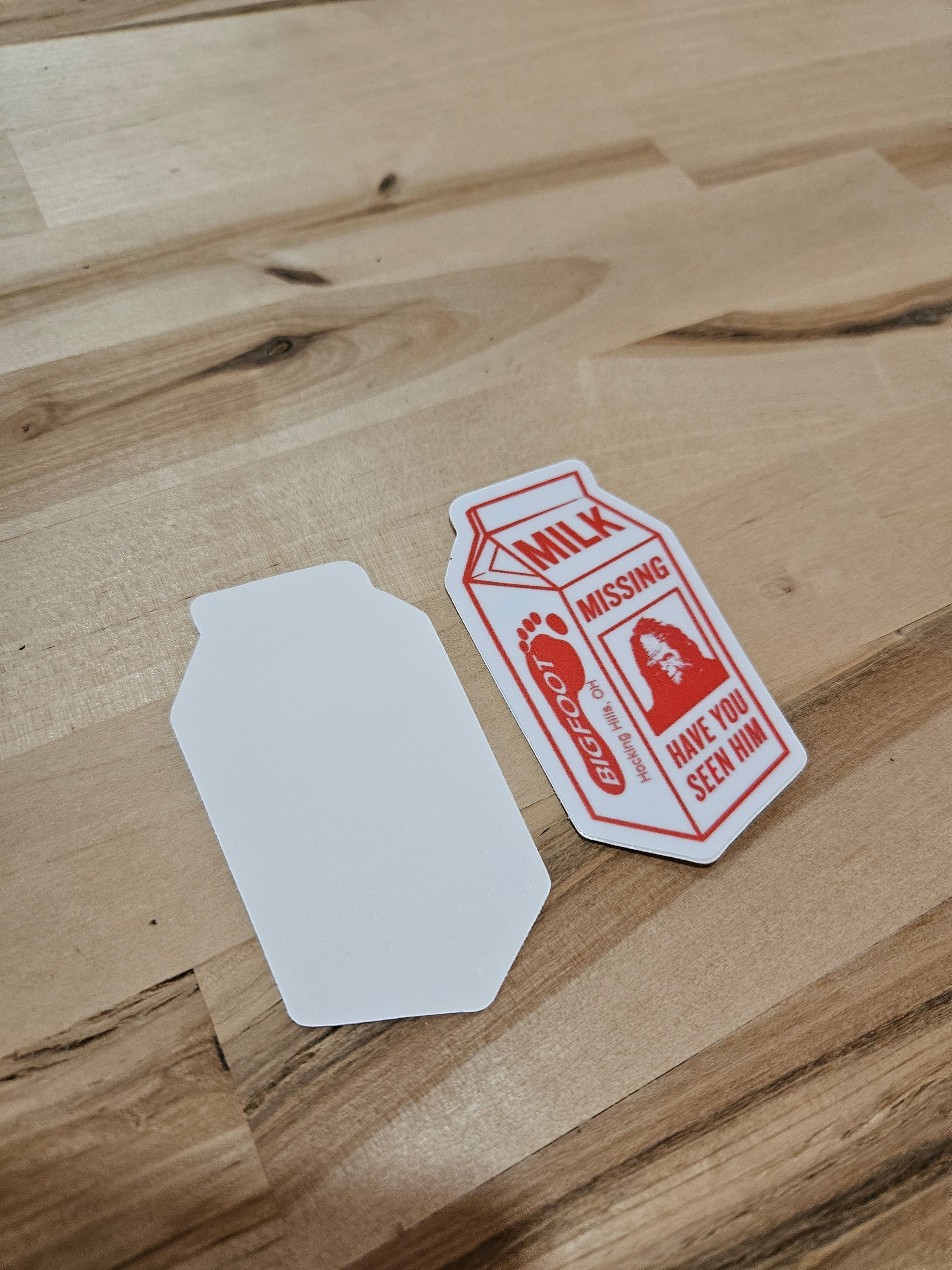 The Hocking Hills Store Bigfoot Missing Bumper Sticker designed like a milk carton with red text and graphics. Features a Bigfoot silhouette.