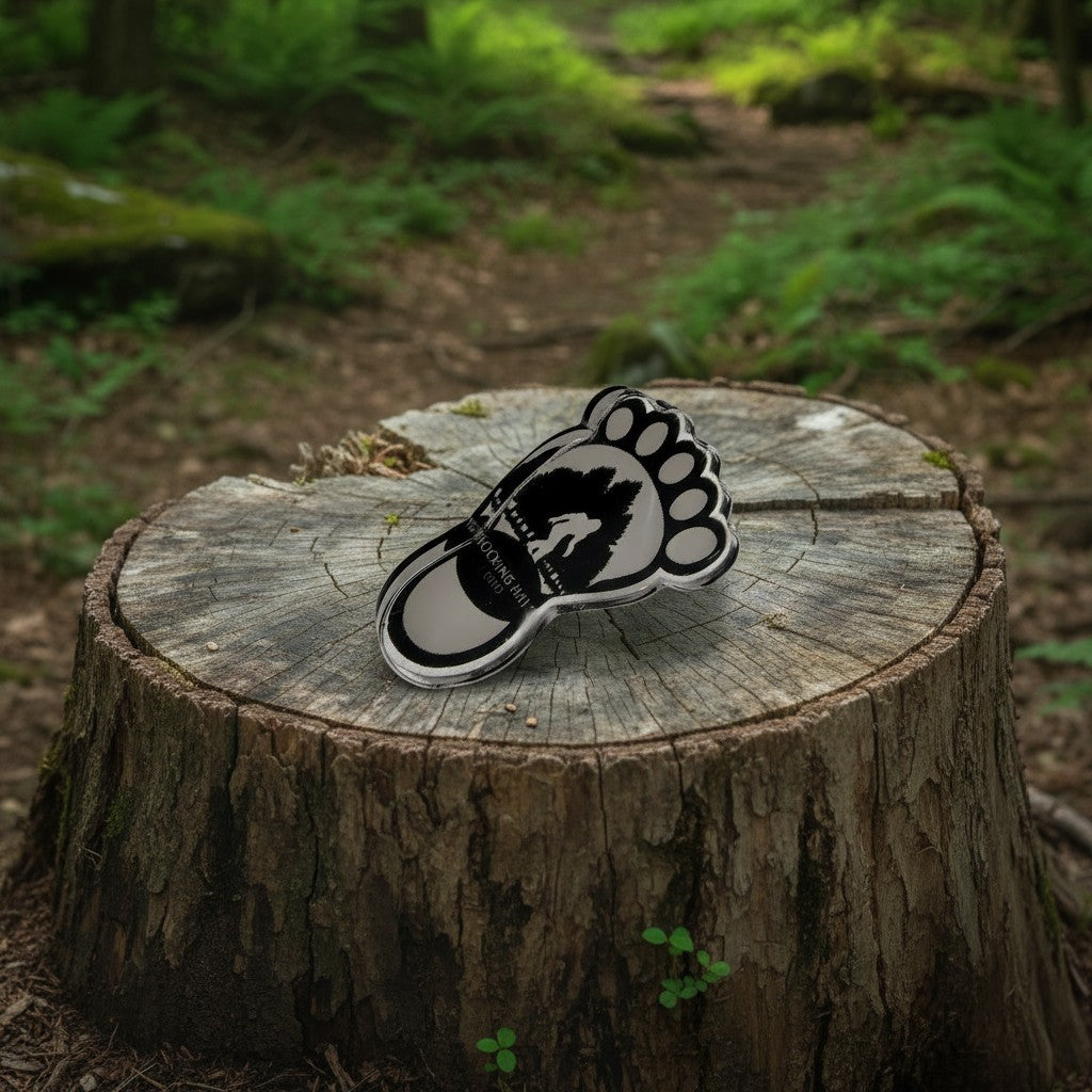 The Hocking Hills Store Bigfoot footprint pin with Bigfoot silhouette and Hocking Hills, Ohio text.