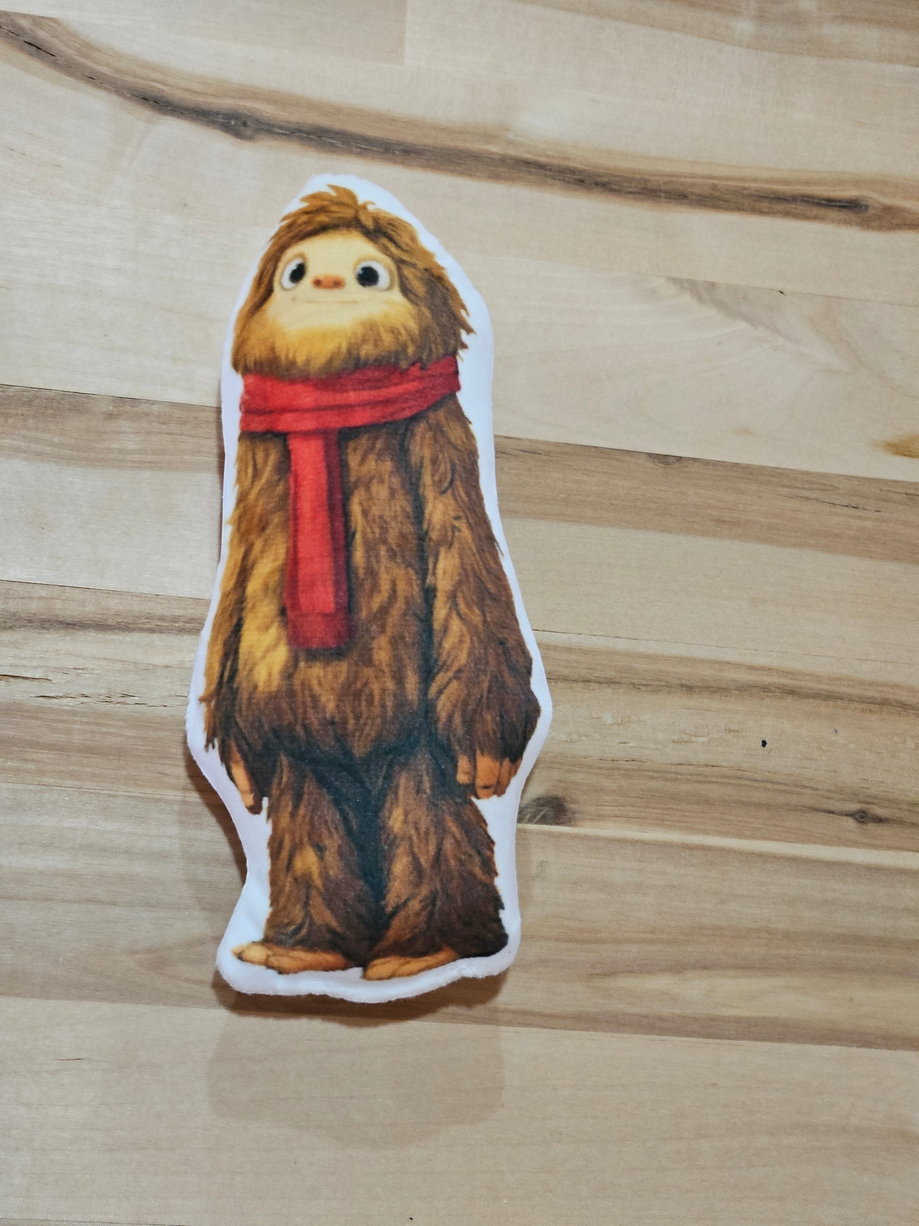 The Hocking Hills Store Small Bobby The Bigfoot plush toy wearing a red scarf. Soft, brown, furry, and designed for imaginative play.