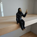 The Hocking Hills Store Bigfoot die-cast statue sits on a shelf, detailed black fur, gold face, and raised finger.