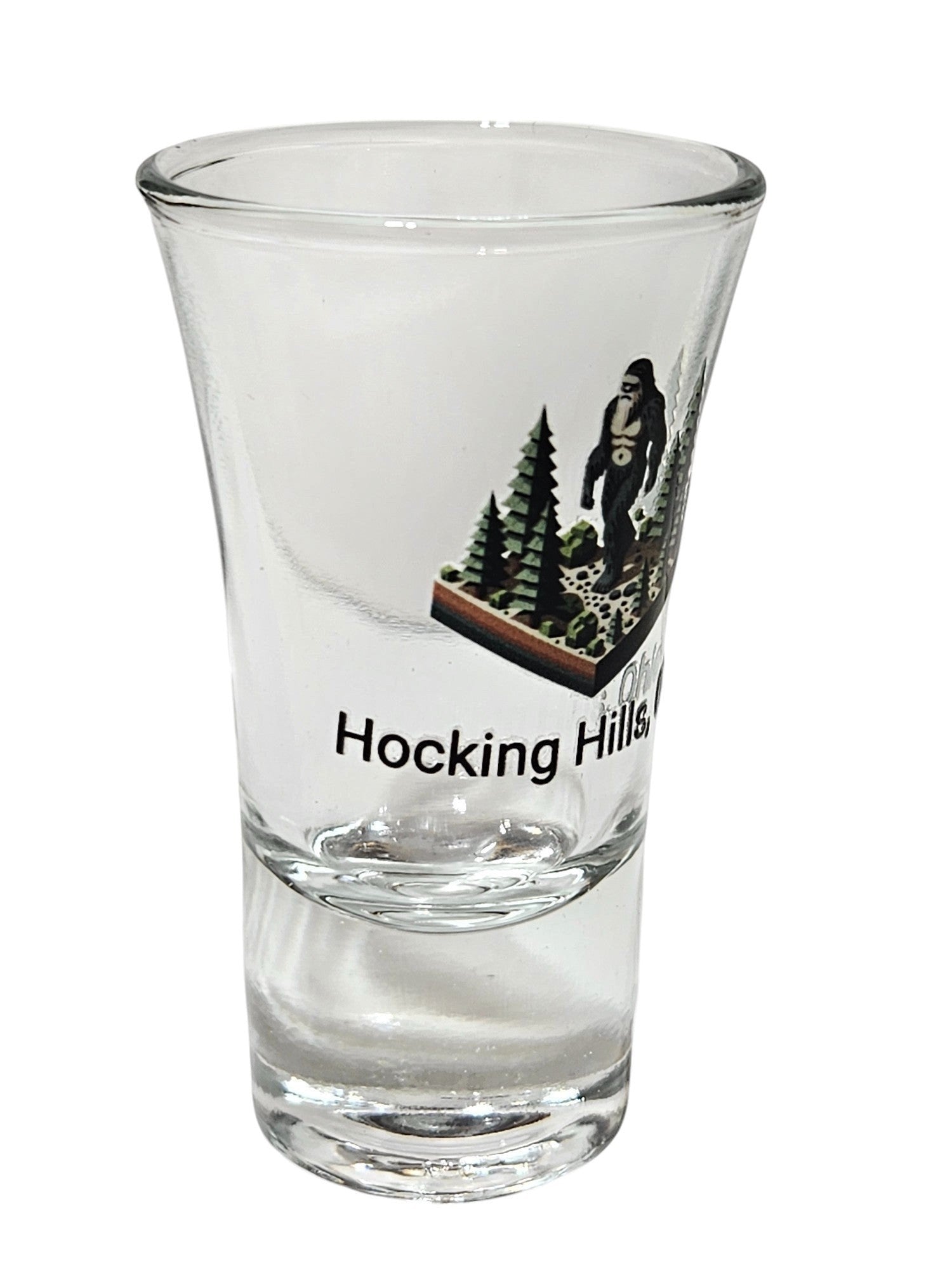 The Hocking Hills Store Bigfoot shot glass features a Bigfoot graphic with trees and text reading "Hocking Hills".