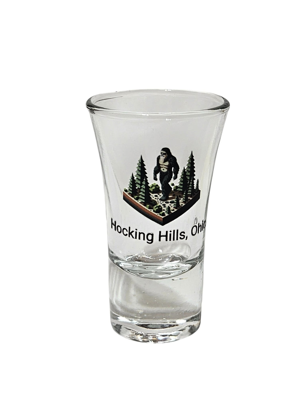 The Hocking Hills Store Bigfoot shot glass with a forest scene and Bigfoot graphic. Text reads Hocking Hills, Ohio.