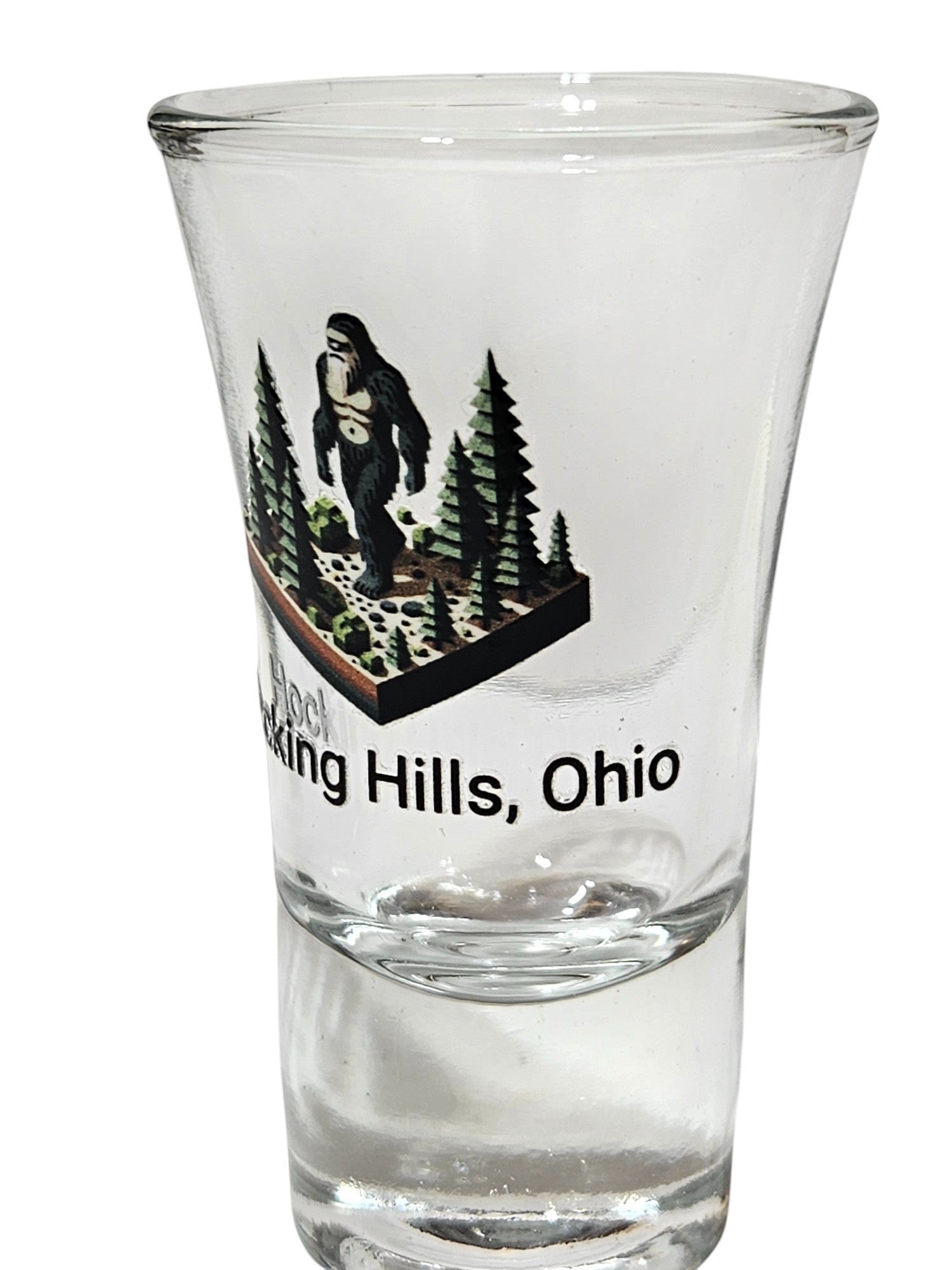 The Hocking Hills Store Bigfoot shot glass features a Bigfoot graphic with pine trees and text reading "Hocking Hills, Ohio".
