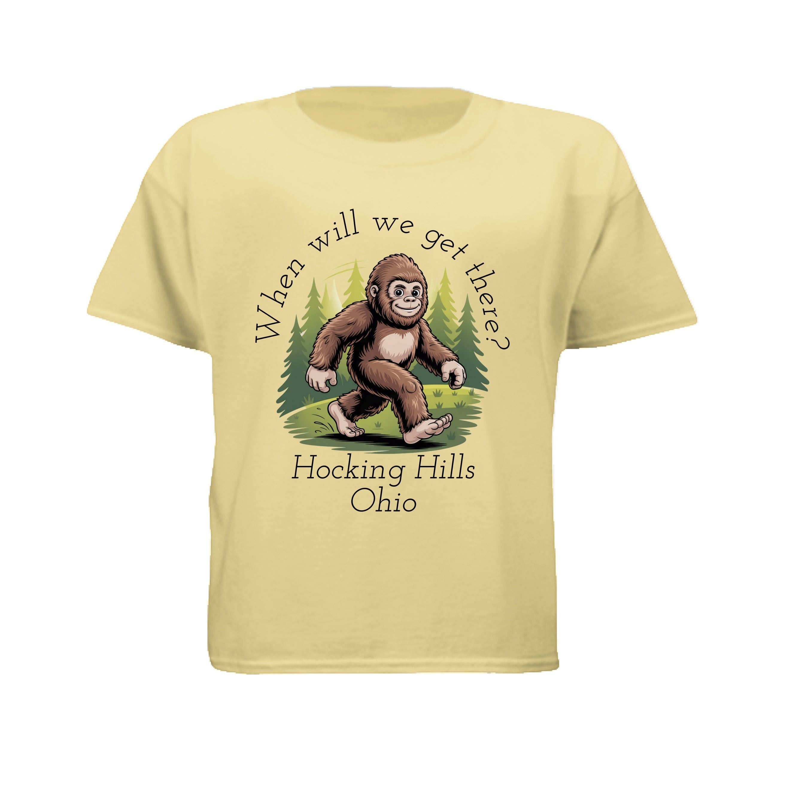 The Hocking Hills Store kids' light yellow Bigfoot t-shirt with a graphic of Bigfoot walking through trees and the text "When Will We Get There? Hocking Hills Ohio."