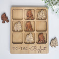 The Hocking Hills Store Bigfoot Tic-Tac-Toe game made of maple and cherry wood. Features Bigfoot and pine tree playing pieces.