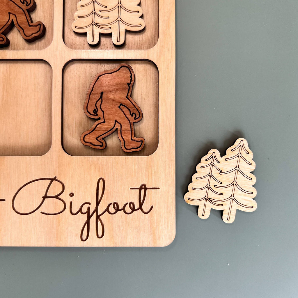 The Hocking Hills Store Bigfoot Tic-Tac-Toe game board made of maple wood with cherry and maple wood playing pieces.