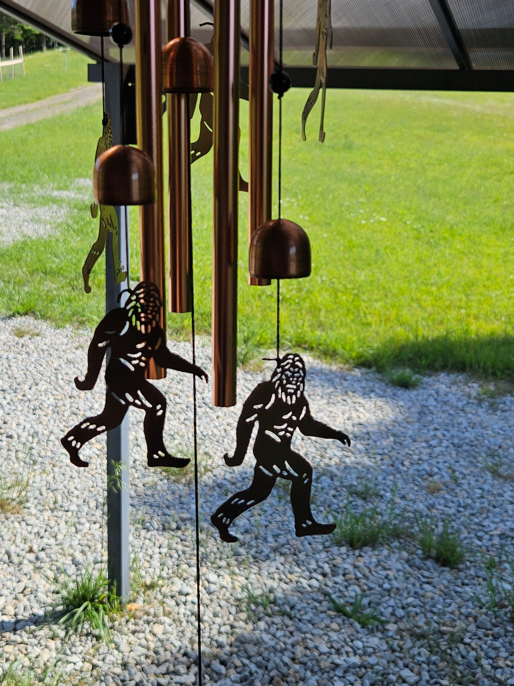 The Hocking Hills Store Bigfoot wind chimes feature copper-colored metal tubes and Bigfoot silhouettes.