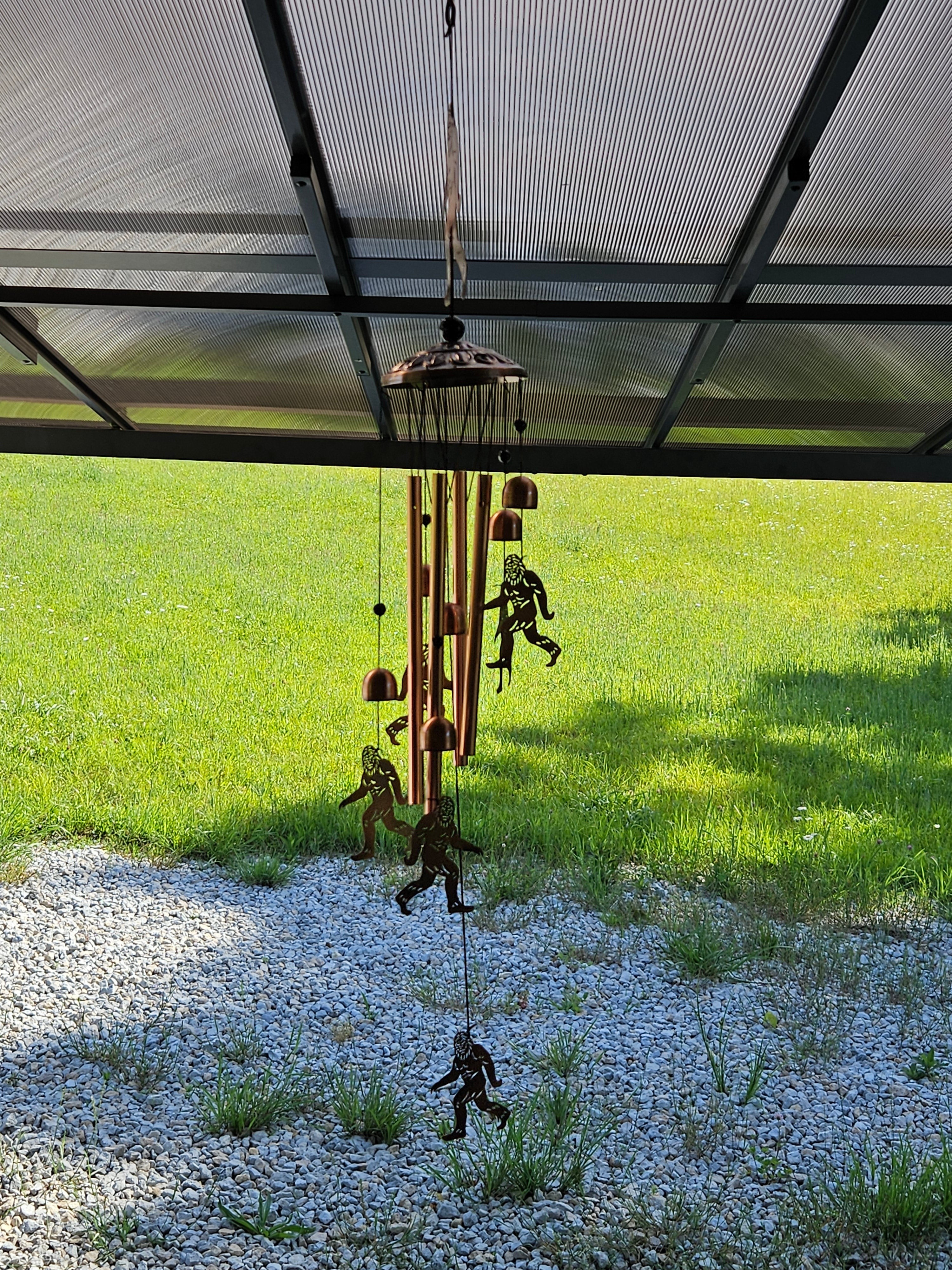 The Hocking Hills Store Bigfoot wind chimes made of metal with copper-colored tubes and Bigfoot silhouettes.
