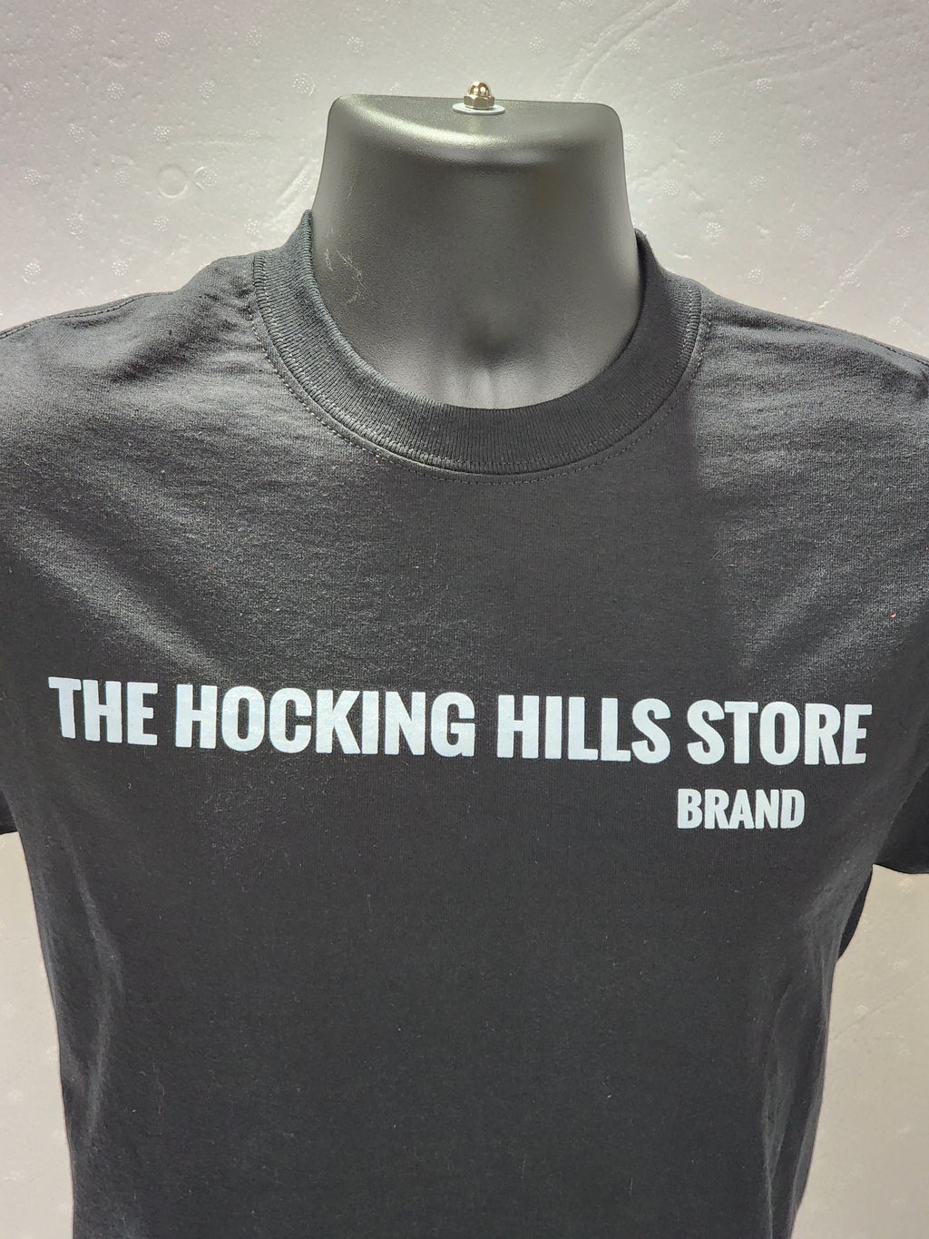The Hocking Hills Store brand black t-shirt with white logo on front. Short sleeve, crew neck, cotton tee.