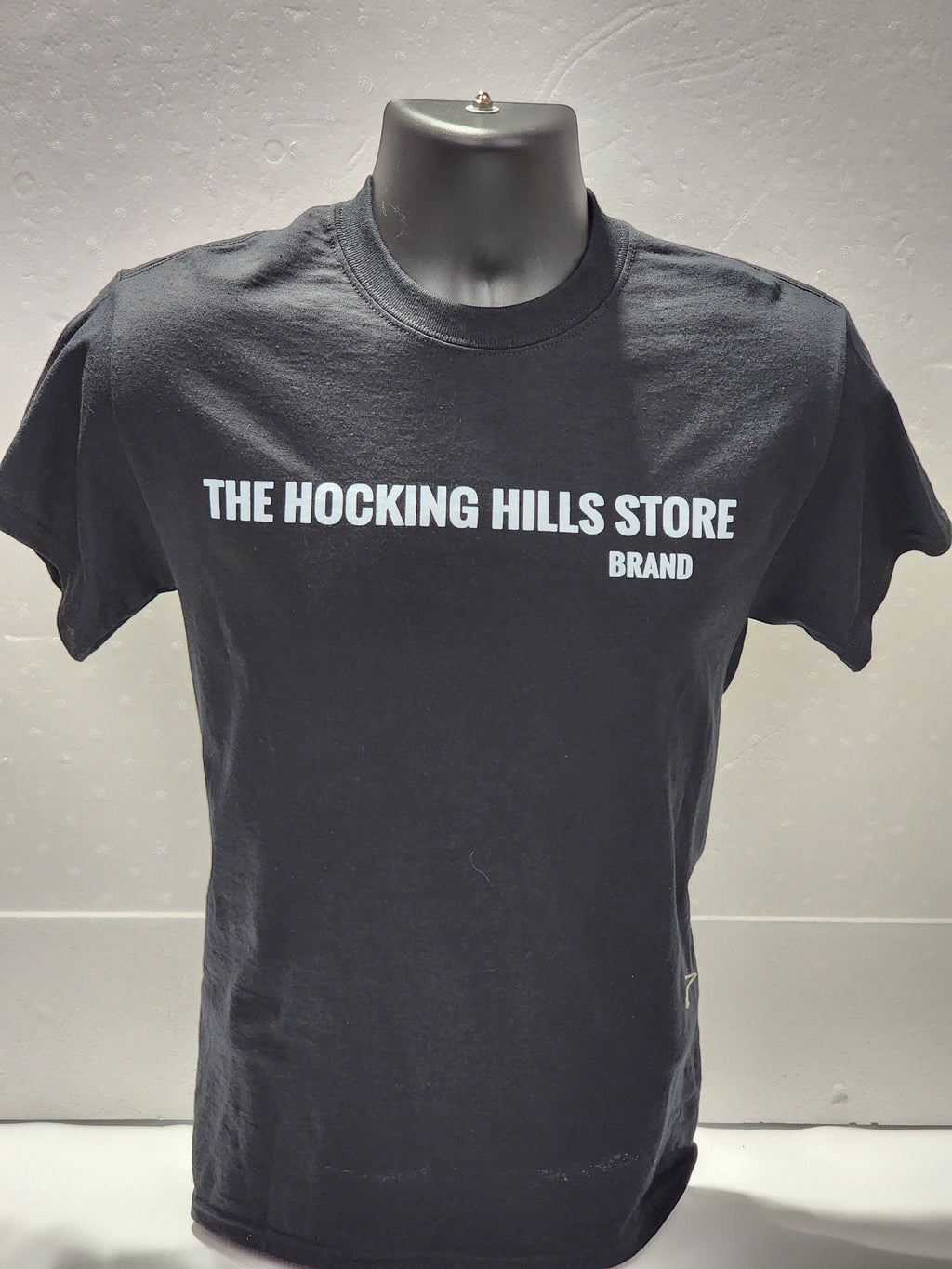 The Hocking Hills Store brand black cotton t-shirt with white logo on front. Short sleeves, crew neck.