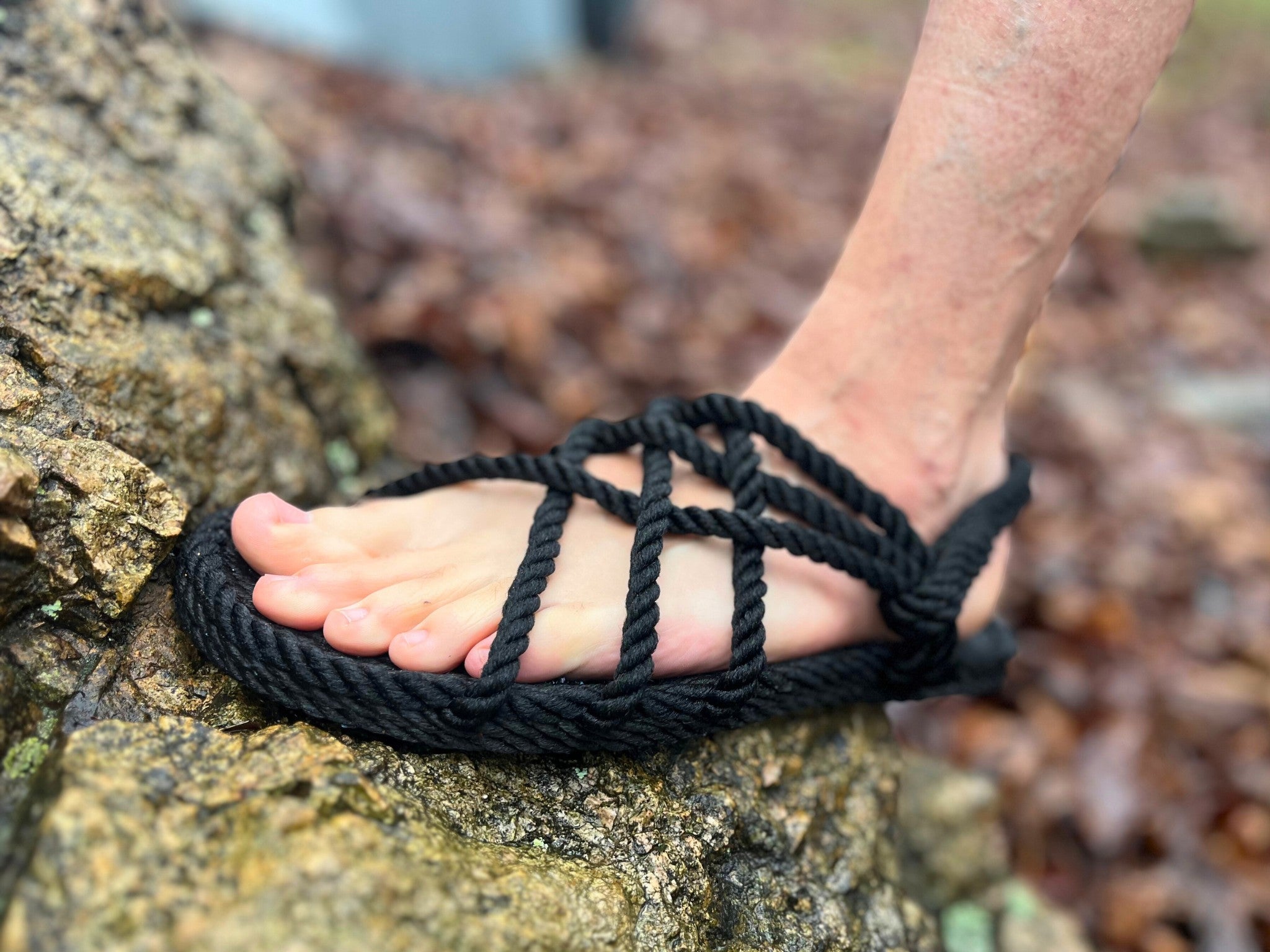 The Hocking Hills Store black polypropylene rope sandals with a unique woven design, worn by a person outdoors on a rock.