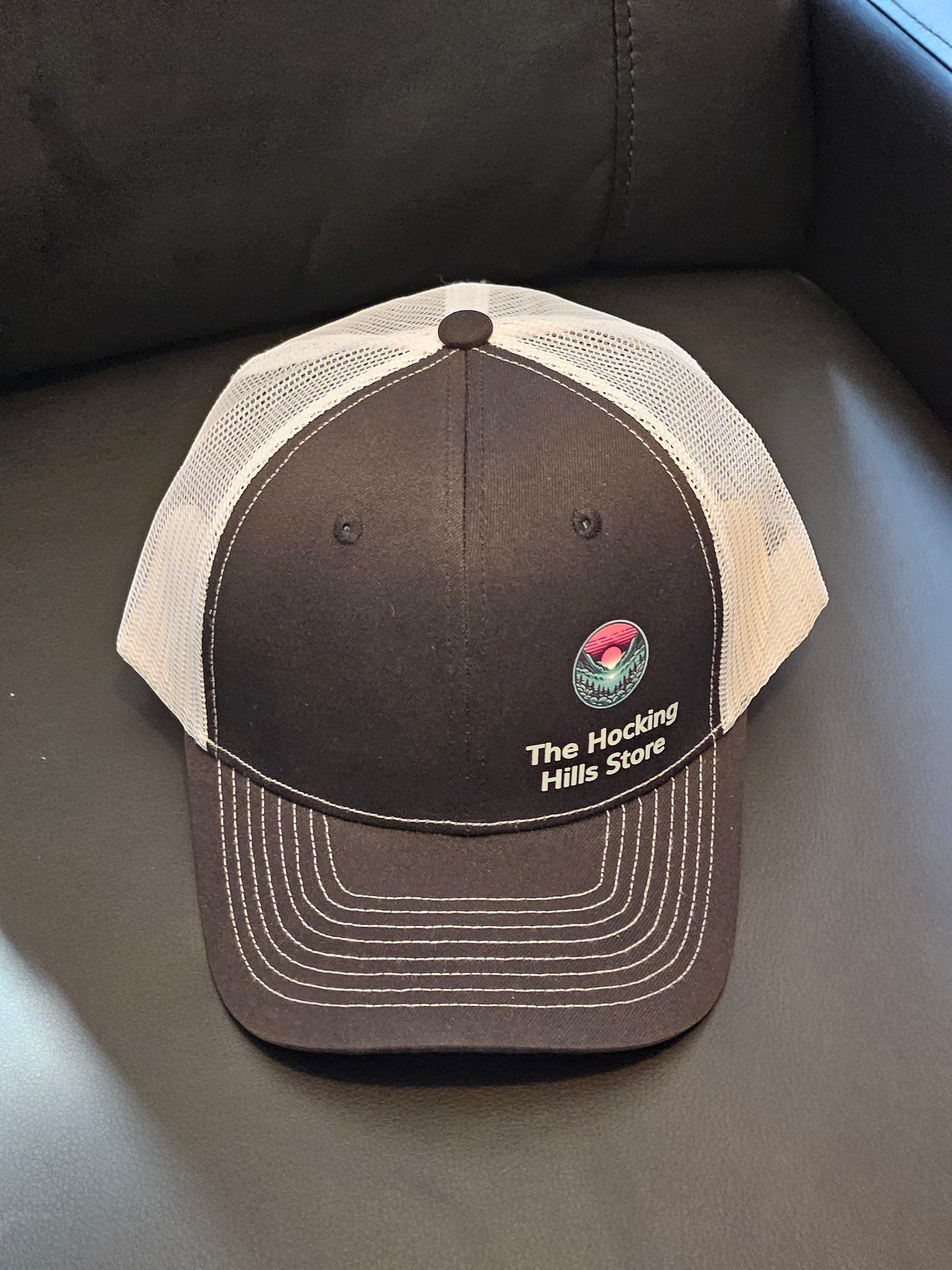 The Hocking Hills Store brown and white trucker hat with embroidered logo. Adjustable mesh back for breathability.