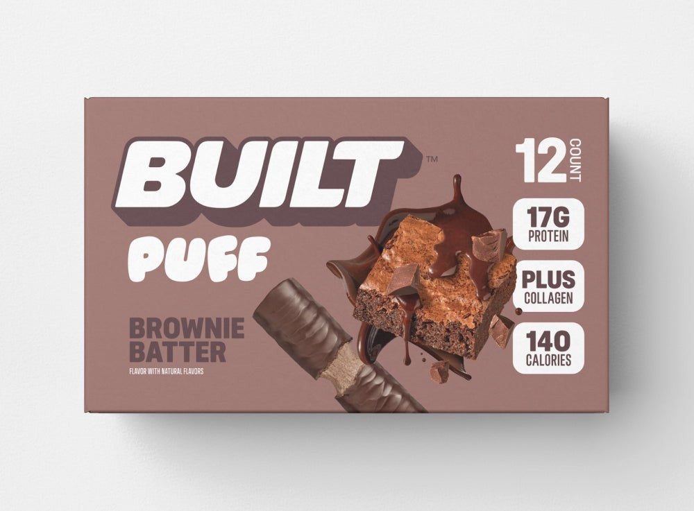 The Hocking Hills Store's Built Puff Brownie Batter protein bar box, featuring 12 bars, 17g protein, plus collagen, and 140 calories. A brownie piece with chocolate drizzle is shown.