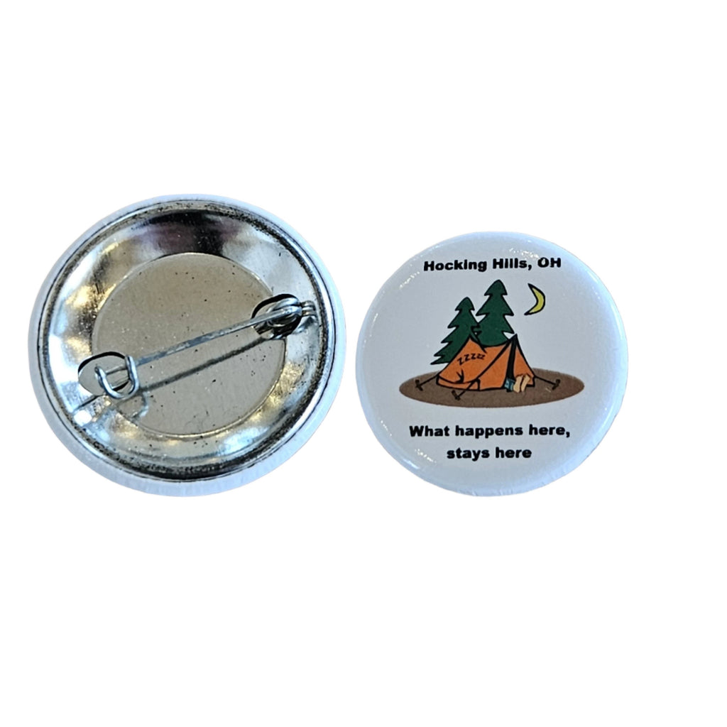 The Hocking Hills Store "What Happens Here Stays Here" camping button featuring a tent, trees, moon, and text.