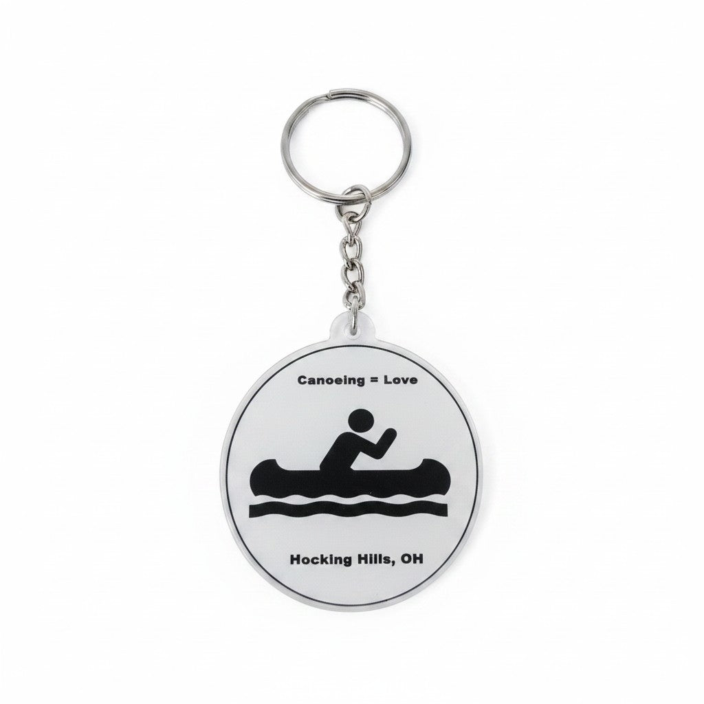 The Hocking Hills Store keychain with a circular design featuring a black silhouette of a person canoeing, the text "Canoeing = Love", and "Hocking Hills, OH".
