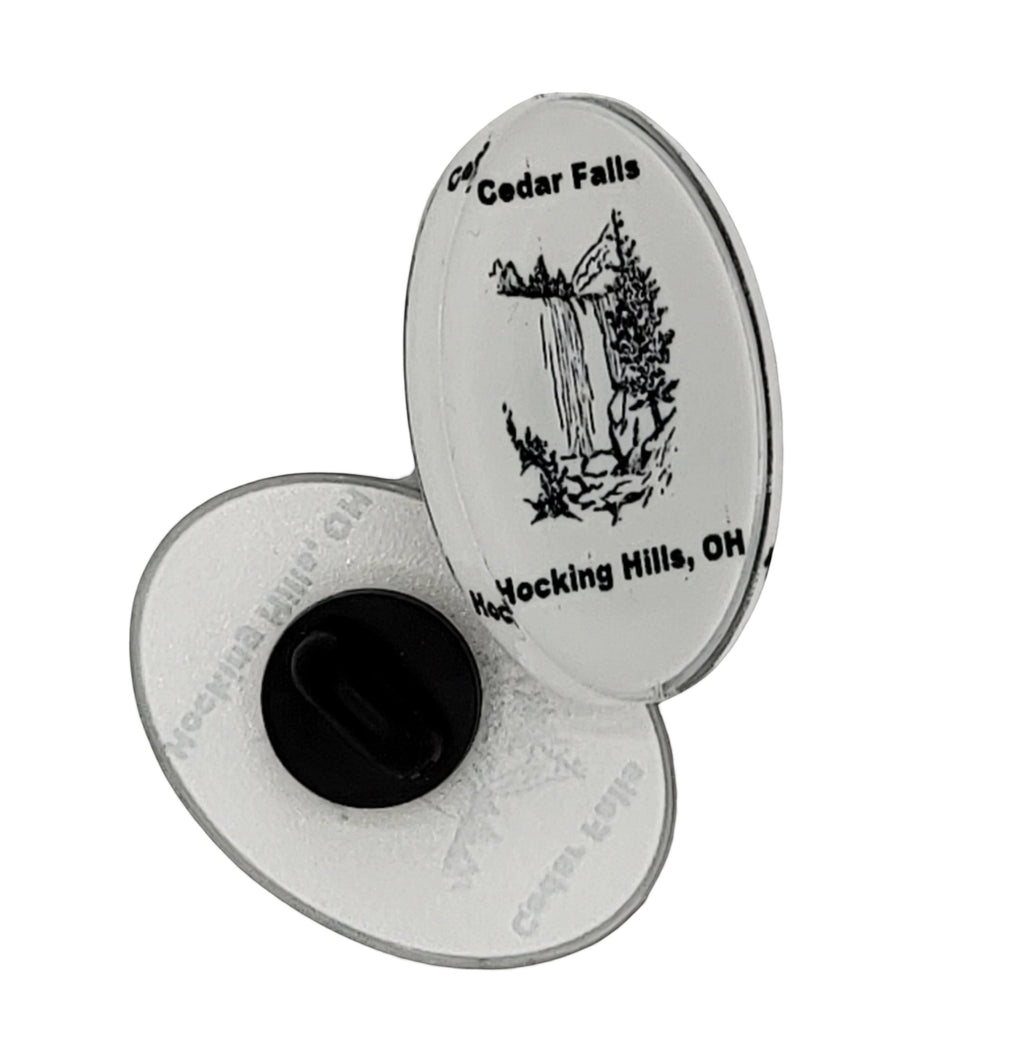 The Hocking Hills Store Cedar Falls oval pin featuring a black and white illustration of a waterfall and trees, with text 'Cedar Falls Hocking Hills, OH'.